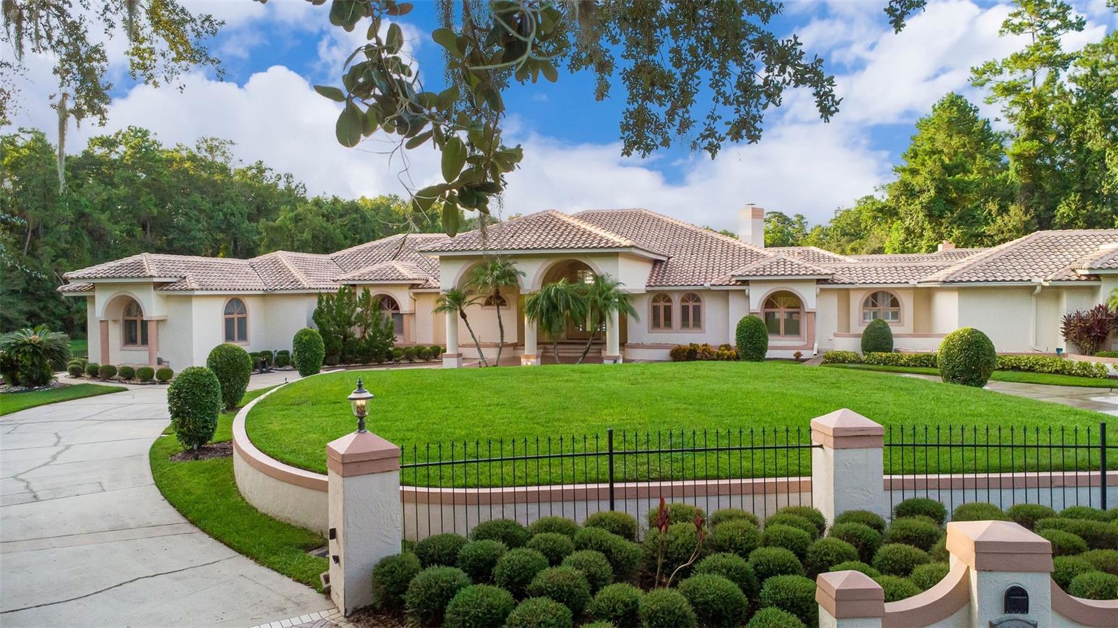 Luxury lives large at this Longwood estate—bold, elegant, and built to impress. Set on 1.04 fully fenced acres with a lake view, this property offers the kind of scale, privacy, and versatility that's nearly impossible to find anymore. Whether you've got a big family, frequent guests, or just need a lot of space to do life your way, this home checks every box—and then adds a few surprises. The main home features four large bedrooms and four bathrooms, plus a long list of bonus spaces you didn't know you needed until now. The primary suite alone could rival most apartments, with a carved-out bonus space perfect for a workout nook, home office, or lounge area—all anchored by a floor-to-ceiling marble fireplace, making it feel more like a retreat than a bedroom. The closet is an entire room in itself, fully built-out & larger than most bedrooms (22'10'' x 33'9'') and the primary bathroom includes a soaking tub, walk-in shower, double vanities, and a private water closet. Every living space in the home was designed for gathering, whether that's the formal dining room, the expansive family room with marble fireplace, dramatic windows & ceiling heights and expansive views of the property, or the formal living area complete with a wet bar and wine cellar because, why not? The eat-in kitchen has its own marble fireplace and is flanked by a butler's pantry and an oversized laundry room. And then there's the library/theater room floor-to-ceiling bookshelves, a bar, and space for the biggest TV you can find (or a projector wall). Hidden behind the entertainment wall? A reinforced safe room with a private exit to the exterior of the home. It can also be accessed discreetly from the primary suite a unique feature that's equal parts cool and practical. Connected to the main home is a full in-law suite with its own living room, dining room, kitchen, bedroom, and 2 full baths. It's ideal for multi-generational living, long-term guests, or just giving everyone a little space and autonomy. Out back, a large, screened patio (36' x 28') with volume ceilings serves as a breezy indoor-outdoor living room. Step beyond the screen and you'll find an oversized pool and spa, set against a lakefront backdrop and framed by a huge open yard ideal for play, pets, gardening, or just enjoying the quiet. A circular driveway and three-car garage complete the layout, offering plenty of parking for guests, toys, or teens. If you're looking for a one-of-a-kind property with flexibility, privacy, and architectural character it's all right here on Earleaf Court .All information taken from the tax record, and while deemed reliable, cannot be guaranteed.