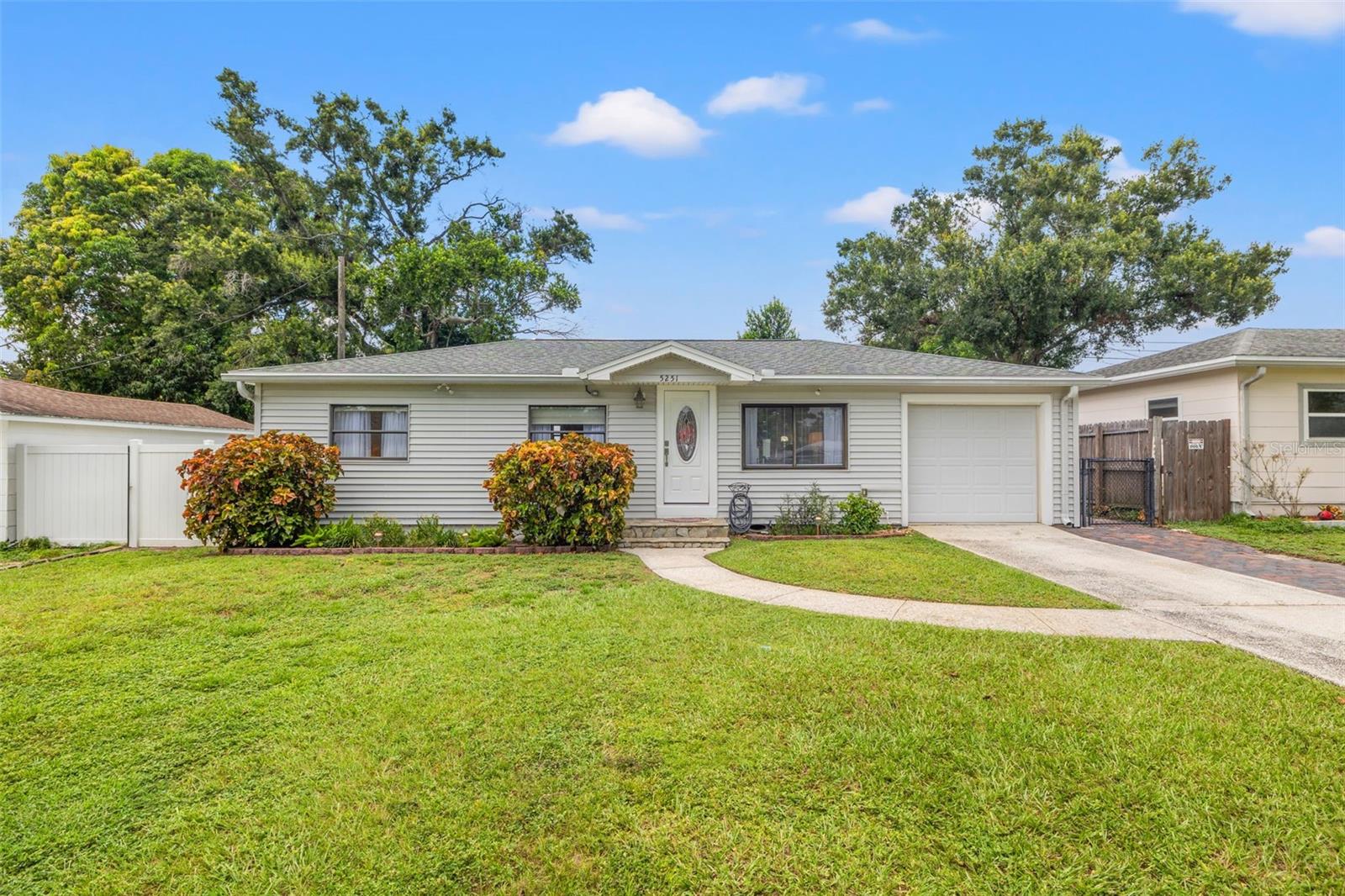 Welcome to this meticulously kept 2-bedroom, 1-bath home offering 816 square feet of thoughtfully designed living space in a St. Petersburg location. From the moment you arrive, it’s clear this home has been lovingly cared for—offering a perfect blend of original charm and modern convenience. Step inside to discover plush carpet - with original hardwood floors underneath, providing timeless character and warmth. The living room is bright and welcoming, featuring custom built-in decorative shelving, updated lighting throughout, and a stunning wood plank ceiling that adds architectural interest and an inviting ambiance. The open-concept layout connects effortlessly to a cozy dinette and updated kitchen complete with Quartz countertops, stainless steel appliances, and ample cabinet space. The generous-sized primary bedroom offers a peaceful retreat, while the full bathroom features ceramic tile floors and stylish finishes. The updates extend throughout the home with new interior doors, a new decorative glass front door, all new GFI electrical outlets, and a hurricane impact glass sliding door for added safety and energy efficiency. Step outside into your own private backyard oasis—featuring a large fenced yard with newer PVC vinyl fencing, an open patio area perfect for relaxing or entertaining, and two detached storage sheds for all your outdoor tools and toys. The irrigation system is connected to a well that has a new pump, helping to maintain lush landscaping year-round. Additional upgrades include: New HVAC system (2023) with ultraviolet light for enhanced air quality, 1-car garage with additional storage space, No flood zone. Convenient location just minutes to I-275, Gandy Blvd, shopping, and specialty dining. Only 20 minutes to St. Pete/Clearwater International Airport and 25 minutes to Tampa International Airport, and easy access to Florida’s top-rated Gulf beaches. Whether you're a first-time buyer, downsizing, or looking for a move-in-ready home with heart, this one is for you.