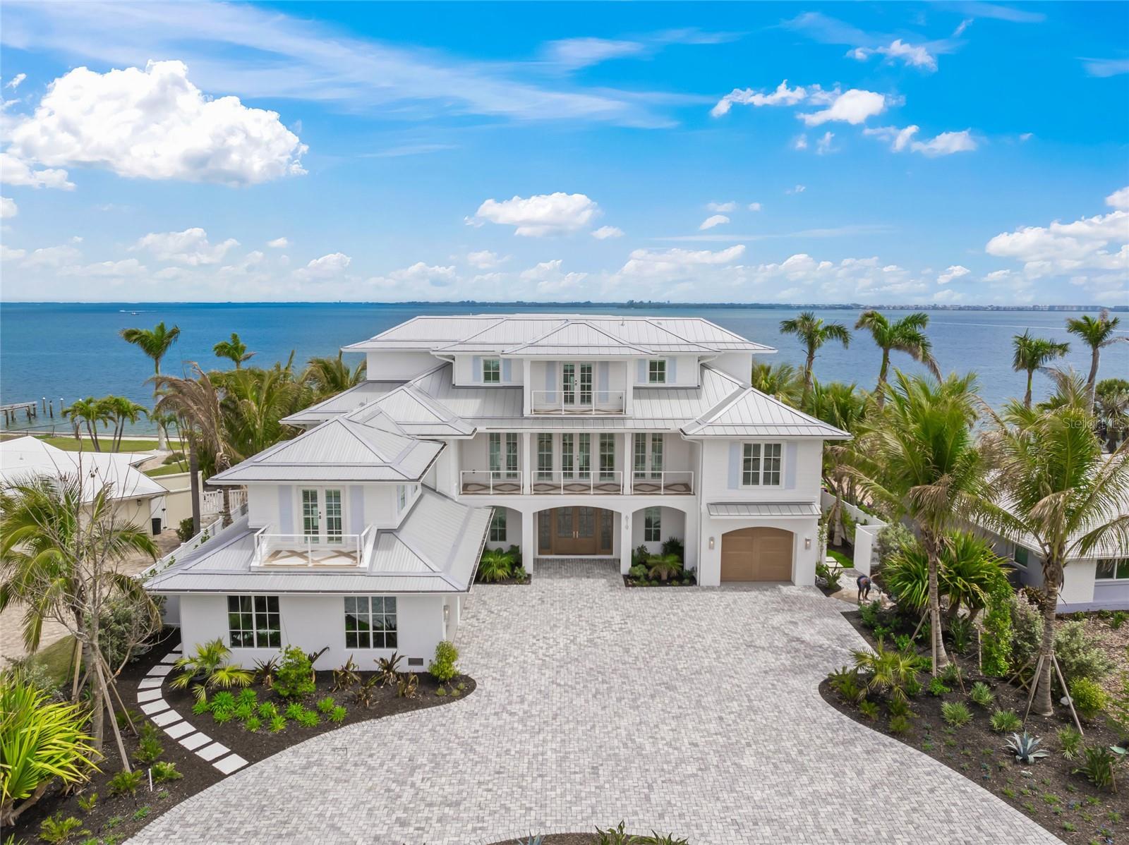 Experience the pinnacle of coastal luxury with this newly constructed bayfront residence on Anna Maria Island. Offered fully furnished with high-end furniture, this home features top-tier Wolf and Sub-Zero appliances and a state-of-the-art Control4 home automation and audio-video system. Thoughtfully designed to capture sweeping panoramic views of Anna Maria Sound, this exceptional home offers five spacious bedrooms—each with its own en-suite bathroom, plus an additional full outside bath and two additional half baths for added convenience.
Perfectly positioned for boating enthusiasts, the property provides seamless access to the Gulf of America and Tampa Bay, with calm, protected waters ideal for sailing. The outdoor living space is a true retreat, featuring a resort-style pool and spa, a fully equipped outdoor kitchen with two Wolf grills, a full workout room, and impeccably designed areas for relaxation and entertaining.
Inside, you’ll find elegant stone countertops, custom cabinetry, and the convenience of a private elevator. A spacious three-car garage adds practicality, while the second floor offers a tranquil primary suite complete with a luxurious en-suite bath, private covered balcony with breathtaking views, and a home office. The third level includes a secondary living area, perfect for guests or multi-generational living.
Ideally located just moments from world-class dining, upscale shopping, and some of the most beautiful beaches in the world, this home offers the ultimate in refined coastal living!