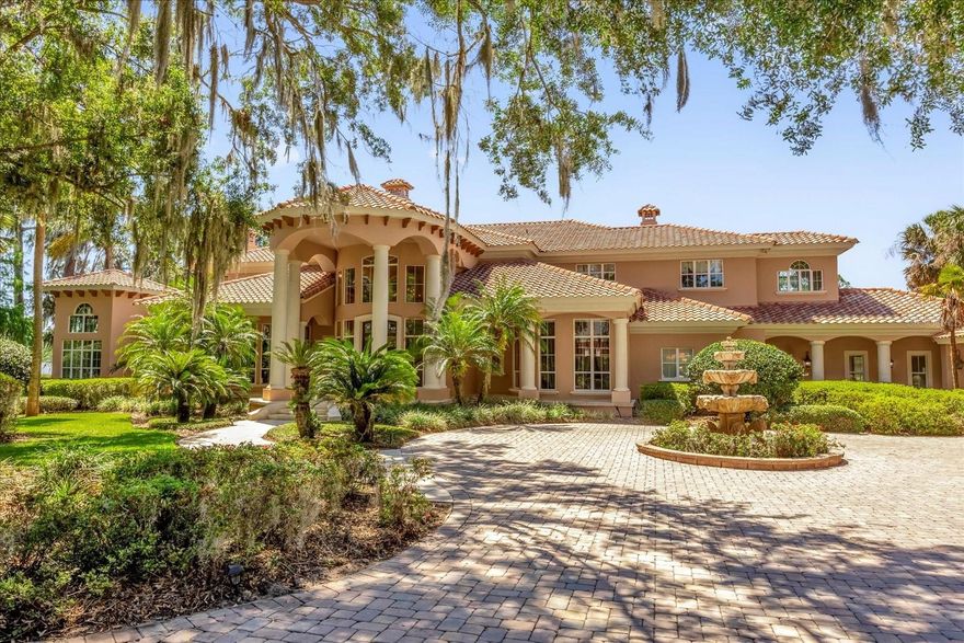 Welcome to an exquisite Old World Style Estate that exudes traditional elegance and grace, nestled on the picturesque shores of Lake Carlton. This exceptional residence, designed by renowned architect Mark Nasrallah, takes inspiration from Addison Mizner's work and spans over 12,000 square feet on a sprawling 5.79-acre lot. The property includes a main home and a separate guest house, both offering breathtaking lake views from nearly every room.The grandeur of the home is immediately apparent with its striking double staircase, surrounded by hand-painted murals of Italy, and a magnificent rotunda. The interiors are adorned with meticulous details, including hand-carved coquina stone fireplaces imported from Mexico, and custom cabinetry and millwork throughout. The circular wrought iron stairs and art-ready galleries add to the home's charm. Outdoor living is elevated with a travertine-surrounded pool area, perfect for enjoying stunning sunsets. The estate includes a boathouse equipped with a hoist for your boat and jet skis, offering easy access to the Harris Chain of Lakes, which connects to the Atlantic Ocean for adventurous boating excursions. The property is thoughtfully designed for privacy and convenience, featuring estate fencing, a gated entrance, and an oversized garage accommodating up to four cars. There is ample space for a tennis or sport court, should you desire. The guest house offers private accommodations with beautiful views, ensuring comfort for visitors. Located just 2 miles from the charming restaurants and shops of Historic Mount Dora, and within easy reach of Maitland-Orlando (30 minutes) and the Airport-Disney area (45 minutes), this home combines serene lakefront living with convenient proximity to urban amenities. Free from HOA or deed restrictions, this unique estate offers negotiable furnishings. Don’t miss the opportunity to experience this masterpiece—schedule your private showing today!