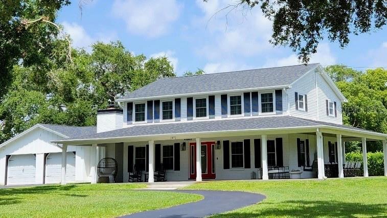 Located in the highly desirable Spanish Trails neighborhood, this beautifully maintained modern farmhouse sits on nearly one acre of private land and offers the perfect blend of charm, functionality, and storm-ready upgrades. With 2,472 heated square feet, this two-story home features 4 bedrooms, 2.5 bathrooms, and a well-designed layout filled with thoughtful touches. The first floor includes a spacious family room, formal living room, elegant dining room, and an eat-in kitchen with hardwood cabinetry, granite countertops, and stainless steel appliances. A former fifth bedroom has been converted into a custom laundry room with a center island, and the entire downstairs showcases hardwood and ceramic tile floors, farmhouse-style doors, and updated finishes. The oversized two-car garage features hurricane-rated doors, epoxy flooring, and new openers. Upstairs, you'll find four spacious bedrooms and two fully renovated bathrooms with quartz countertops and modern tilework, along with original pegged oak hardwood floors and plantation shutters throughout.
Outdoor living is elevated with a 600+ square foot wraparound porch, a screened lanai, grilling area, firepit, and a custom-built shed—perfect as a studio or workspace. The grounds are beautifully landscaped with three freshly trimmed oak trees and a circular driveway. The backyard is an oasis of privacy with a new (2025) steel-reinforced wooden fence along the eastern border of the property, and a row of podocarpus hedges along the southern border of the property. Likewise, the homeowner to the north planted a row of podocarpus hedges, giving the property symmetry, privacy, and protection on all sides.
Major upgrades include a 2023 30-year shingle roof (transferable warranty), Simonton impact windows and PGT doors (lifetime warranty), hurricane-rated garage doors, a newer Lennox dual-zone A/C system (under warranty), and a whole-house Generac generator with a 500-gallon buried propane tank. Additional features include a private-well irrigation system, WiFi-enabled programmable Trim Lights, and front and rear security cameras. This is a rare opportunity to own a fully upgraded, storm-resilient home in one of Dunedin’s most sought-after custom home communities, just minutes from the Gulf, downtown Dunedin, and top-rated schools.