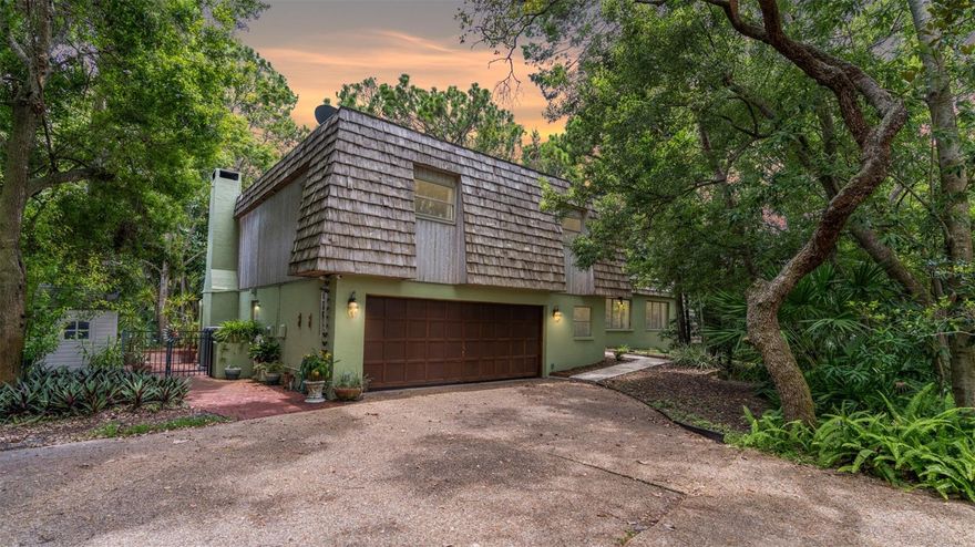 Tucked away on an award-winning, one-acre homesite wrapped in native Florida foliage, this architect-designed retreat blends thoughtful craftsmanship with nature’s calm just minutes from lively downtown Dunedin, offering more than 3,100 square feet across a 4-bed, 3-bath main residence plus a separate, air-conditioned studio ideal for creative work, a quiet office, fitness, or future guest quarters; inside, generous living and dining areas flow to a warm family room with fireplace, while the entertainer’s island kitchen showcases custom shaker cabinetry and abundant prep space, and the private primary suite unfolds to a balcony perched above the grounds, complemented by oversized secondary bedrooms that deliver room to grow, gather, and recharge; meaningful updates include a 2021 roof, impact-rated windows and doors, and an oversized two-car garage, and outside the lifestyle expands under the oaks with a shaded gazebo, built-in grill, and paver patio set amid lush landscaping certified as a backyard wildlife habitat—privacy with purpose in a rare, nature-forward setting; moments from Honeymoon and Caladesi Islands, Clearwater Beach, and Dunedin’s beloved shops, cafés, and golf, this architecturally significant property offers a one-of-a-kind chance to own a serene retreat in one of Tampa Bay’s most desirable communities.