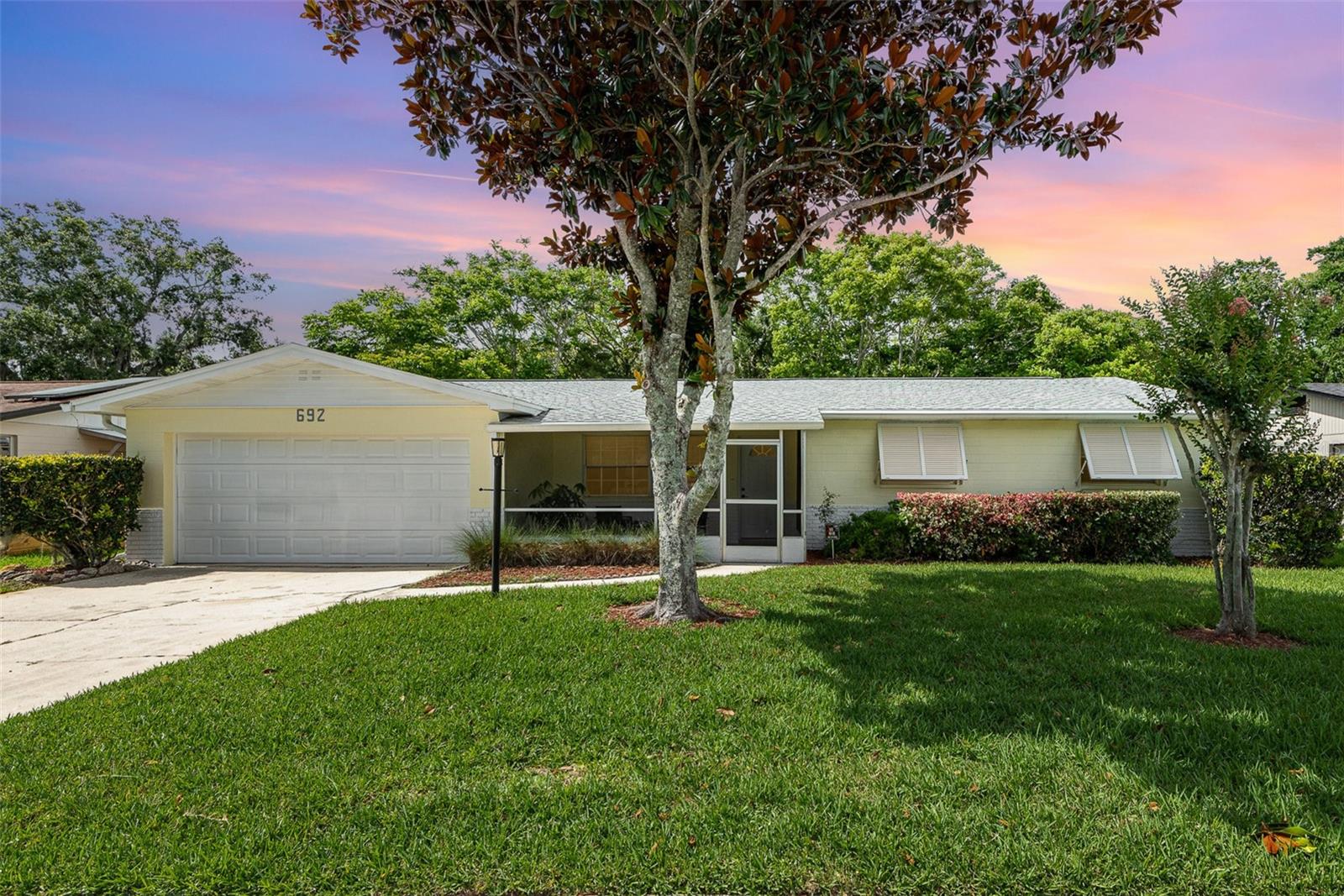 One or more photo(s) has been virtually staged. This beautifully updated concrete block home offers the perfect blend of modern design, comfort & functionality. Featuring 3 spacious bedrooms, 2 full bathrooms and a 2-car garage, this home has been freshly painted inside & out with an inviting, open-concept layout ideal for entertaining. Totally remodeled in 2023 with new roof, new kitchen, new appliances (including washer/dryer), new bathrooms, new luxury vinyl flooring and ceiling fans., New A/C motor in 2024 and hot water heater in 2020. A welcoming screened front porch with matte epoxy flooring—rescreened just two years ago—creates the perfect space to relax outdoors. Inside, luxury vinyl plank flooring flows throughout the home, enhancing its cohesive/contemporary feel. At the heart of the home, the stunning kitchen is a true showstopper. A custom-designed movable island includes a removable center section and wraparound seating, offering flexibility & function. Elegant Quartz countertops are complemented by new GE Smart Appliances, all app-controlled for convenience. Additional kitchen features include a deep stainless-steel sink, soft-close drawers, a full pull-out pantry and built-in spice & cookie sheet storage. A dedicated coffee or appliance bar features upper cabinetry with beautiful seed glass also echoed in the display cabinet perfect for showcasing fine china. The open family room, currently used as a dining area, provides flexible living space, while the oversized kitchen easily accommodates informal dining. The generously sized, enclosed lanai features a newly refinished matte epoxy floor. Bedrooms are well-proportioned. The spacious primary suite includes a fully remodeled en-suite bath with a tiled walk-in shower, built-in quartz seat, and upgraded vanity with quartz countertop. The second bedroom currently serves as an office. The third bedroom is equally spacious. The fully remodeled guest bath features impressive high-end finishes. Additional features include a 2023 smart washer/dryer set located in the garage, utility splash tub & newly installed side-entry door. Throughout the home, smooth ceilings add to the modern aesthetic. The living room has two closets for additional storage. Gutter guards are installed on gutters to prevent leaf buildup and easy maintenance. Seller has professionally sealed the foundation adding important advantages with Florida’s humid climate, rainfall, and high-water tables. Benefits: to sealing the foundation: 1. Moisture Protection - Prevents water intrusion into the foundation, which can lead to mold, mildew, and rot. Reduces humidity levels in crawl spaces or basements, improving air quality. 2. Flood & Storm Resilience - Sealing adds a layer of protection against minor flooding or pooling water. 3. Pest Prevention - Helps block entry points for termites, ants, and rodents, which are common in Florida. 4. Structural Longevity - Protects concrete from erosion and weakening over time due to moisture infiltration. Helps prevent cracking, settling, or spalling, preserving structural integrity. 5. Energy Efficiency - By reducing air and moisture leaks, it can improve HVAC performance and lower cooling costs important in Florida's hot climate. 6. Property Value & Maintenance Savings -Demonstrates proactive home maintenance Plus - custom hurricane shutters!! This loved home is loaded with thoughtful upgrades and stylish finishes truly move-in ready. Come experience the quality and comfort this beautiful property has to offer!