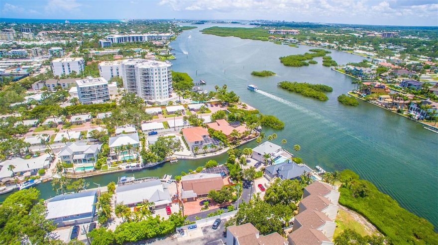 Discover Unrivaled Coastal Elegance Steps from Siesta Key Beach!
This rare gem features two meticulously remodeled canal-front homes with stunning partial views of the bay, perfectly situated in a prestigious neighborhood. The main residence boasts a contemporary design with open and spacious layouts, highlighted by soaring 24 ft ceilings adorned with stylish gray wooden accent beams. Culinary enthusiasts will be captivated by the gourmet kitchen, featuring custom-made wood cabinets complemented by exquisite Carrara Quartz countertops. Equipped with top-of-the-line appliances, including a new stainless Thermador refrigerator, Bosch dishwasher, and an impressive center island with a bar area, it truly caters to the most discerning chefs.
Zoned RMF2 while located in a single-family neighborhood, this property allows for daily Airbnb rentals, making it an excellent investment opportunity. A private, charming guest cottage serves as an ideal retreat or rental for additional cash flow. Recent upgrades include new Window World Hurricane-rated windows, French doors, and a newly installed seawall (2025), ensuring your investment remains safe and secure.

The main house spans 3,005 sq ft, featuring three bedrooms and 2.5 baths adorned with luxurious Panaria marble and 24x48 tile flooring. Bathrooms boast contemporary Miseno vanities and premium Grohe and Hansgrohe fixtures. The decadent master suite invites relaxation with a rain cap shower and a sumptuous soaking tub. Both homes are equipped with new Rheem A/C units, while the property’s outdoor oasis features a large screened lanai overlooking the canal and bay. Dive into the newly resurfaced pool with a stunning stone waterfall or enjoy the expansive outdoor space, surrounded by tropical landscaping.
The cozy guest cottage, covering 1,700 sq ft, includes three bedrooms and two full baths, showcasing beach-washed ceramic tile flooring, white wood Shaker cabinets, and modern KitchenAid and Bosch appliances. The new dock provides easy access to pristine boating waters with no bridges obstructing your path to the bay. Siesta Key is a haven for music lovers and foodies alike, while Sarasota delights with its vibrant art scene, ballet performances, the Asolo Performing Arts Center, the Ringling Art Museum, and world-class shopping. Relax with your favorite beverage on the rear patio, shaded by a majestic live oak, or grab your fishing rod, bathing suit, and water toys to fully embrace the Siesta Salt Life. Act fast! This exquisite property offers a luxurious lifestyle and lucrative potential in one of Florida’s most sought-after destinations!