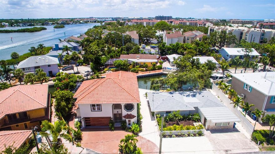 Discover Unrivaled Coastal Elegance Steps from Siesta Key Beach!
This rare gem features two meticulously remodeled canal-front homes with stunning partial views of the bay, perfectly situated in a prestigious neighborhood. The main residence boasts a contemporary design with open and spacious layouts, highlighted by soaring 24 ft ceilings adorned with stylish gray wooden accent beams.Culinary enthusiasts will be captivated by the gourmet kitchen, featuring custom-made wood cabinets complemented by exquisite Carrara Quartz countertops. Equipped with top-of-the-line appliances, including a new stainless Thermador refrigerator, Bosch dishwasher, and an impressive center island with a bar area, it truly caters to the most discerning chefs.
Zoned RMF2 while located in a single-family neighborhood, this property allows for daily Airbnb rentals, making it an excellent investment opportunity. A private, charming guest cottage serves as an ideal retreat or rental for additional cash flow. Recent upgrades include new Window World Hurricane-rated windows, French doors, and a newly installed seawall (2025), ensuring your investment remains safe and secure.

The main house spans 3,005 sq ft, featuring three bedrooms and 2.5 baths adorned with luxurious Panaria marble and 24x48 tile flooring. Bathrooms boast contemporary Miseno vanities and premium Grohe and Hansgrohe fixtures. The decadent master suite invites relaxation with a rain cap shower and a sumptuous soaking tub. Both homes are equipped with new Rheem A/C units, while the property’s outdoor oasis features a large screened lanai overlooking the canal and bay. Dive into the newly resurfaced pool with a stunning stone waterfall or enjoy the expansive outdoor space, surrounded by tropical landscaping.
The cozy guest cottage, covering 1,700 sq ft, includes three bedrooms and two full baths, showcasing beach-washed ceramic tile flooring, white wood Shaker cabinets, and modern KitchenAid and Bosch appliances. The new dock provides easy access to pristine boating waters with no bridges obstructing your path to the bay. Siesta Key is a haven for music lovers and foodies alike, while Sarasota delights with its vibrant art scene, ballet performances, the Asolo Performing Arts Center, the Ringling Art Museum, and world-class shopping. Relax with your favorite beverage on the rear patio, shaded by a majestic live oak, or grab your fishing rod, bathing suit, and water toys to fully embrace the Siesta Salt Life. Act fast! This exquisite property offers a luxurious lifestyle and lucrative potential in one of Florida’s most sought-after destinations!