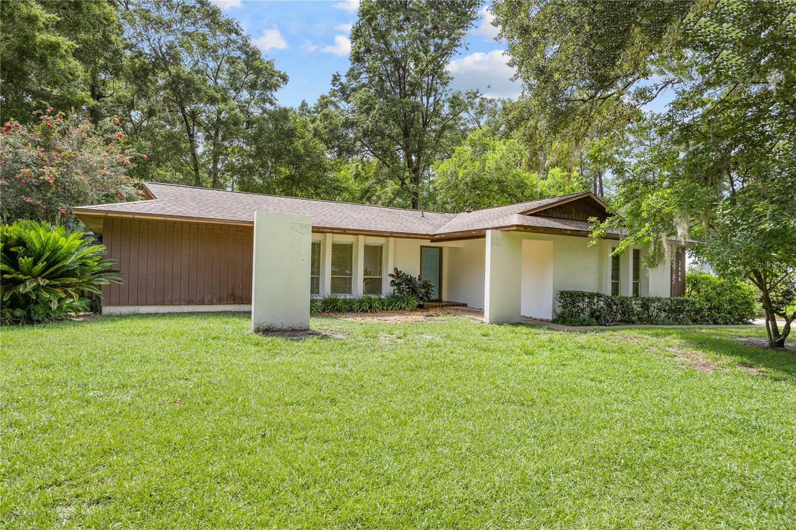 Welcome Home to this well maintained 4-bedroom, 3-bath classic concrete block home built by Rutenberg, located in the highly desirable Rock Creek neighborhood in NW Gainesville. Situated on nearly half an acre, this home offers a spacious 3-way split floor plan with vaulted ceilings, tile and wood flooring throughout, and a cozy brick wood-burning fireplace with custom built-in shelving. Enjoy Florida living at its finest with a large fenced backyard, a sparkling pool with a built-in hot tub, and a newer screened enclosure for year-round enjoyment. The expansive enclosed tiled porch adds valuable indoor-outdoor living space—perfect for entertaining or relaxing. Recent updates include a 2017 roof and 2019 HVAC system for peace of mind. Don't miss this opportunity to own a solidly built home with timeless charm in one of NW Gainesville’s most established neighborhoods!