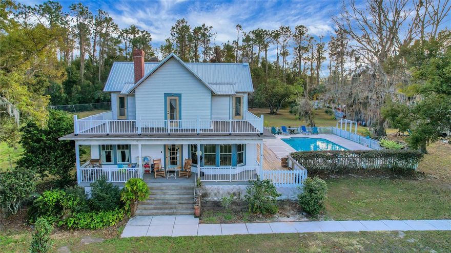 An extraordinary opportunity awaits in the highly desirable area of Yalaha, just minutes from Howey-in-the-Hills, Mount Dora, and South Leesburg. This beautiful 6.44 acre property offers a variety of incredible features including a sparkling pool, small guest house, tractor barn, and a pole barn. This stunning two-story pool home is a true showpiece, boasting 3,556 square feet of heated living space with five spacious bedrooms, three full baths, and one half bath. A new metal roof was added in 2019, enhancing both durability and curb appeal. Inside, the home is filled with charm and character, from its beautiful wood floors and crown molding to the wood windows and exposed beams that accent the living room, dining room, and the downstairs primary bedroom. Upstairs, a cozy loft area provides a charming retreat, while a second primary suite adds to the home’s versatility. The remodeled eat-in kitchen offers ample storage space with an island, and the oversized indoor laundry room provides plenty of space for additional storage, a second refrigerator, or a freezer. Step onto the rooftop deck and take in the breathtaking views of Lake Harris.  With so much to offer in such a sought-after location, this is an opportunity that won’t last long. Please call to get the personalized videos and 3D Matterport of the property. Schedule your showing today!