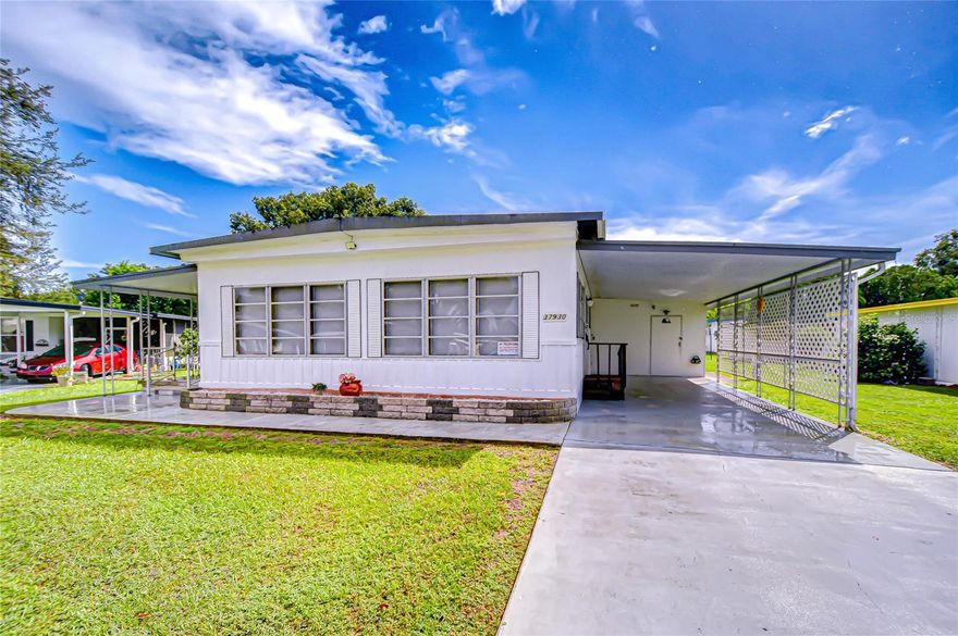 This furnished 2-bedroom, 2-bath mobile home is ready for you to move in and make it your own. Step inside to the dining area, with the kitchen conveniently located to the right, offering a smooth-top range, refrigerator, standalone microwave, closet pantry, and ample cabinet space. The spacious living room flows seamlessly into the Florida room, creating extra space for relaxing or entertaining. At the back of the home, you’ll find two comfortable bedrooms. The primary suite features a walk-in closet and an en suite bath with a tub/shower combo, while the guest bedroom and full hall bath are perfect for visitors. On the outside you have front and rear open patios with a shed at the end of carport that houses the washer and dryer. Whether you’re seeking a seasonal getaway or a full-time residence, this home offers a cozy retreat from the northern winters.