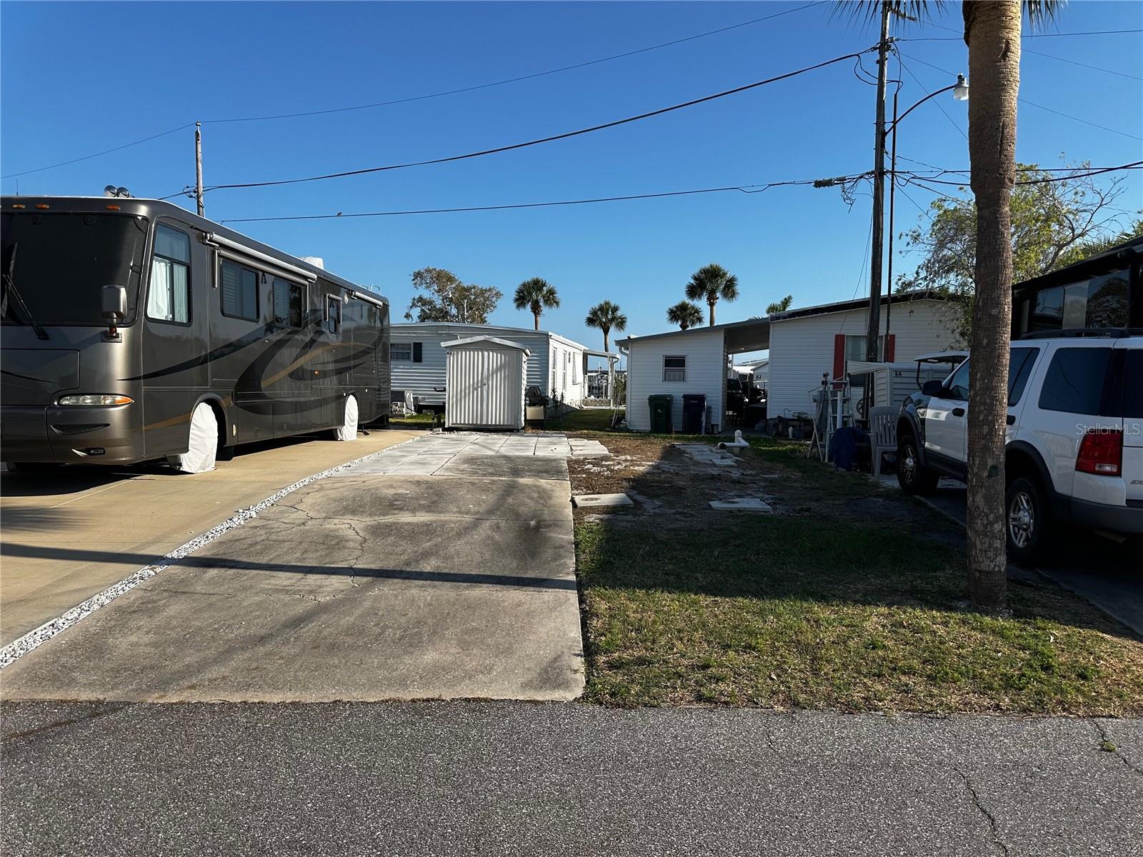 RV LOT Opportunity in TROPIC ISLES COOP – Your Sun Coast Retreat Awaits! Seize this rare chance to own an RV lot in Tropic Isles, a 55+ Resident Owned Waterfront community! If you're looking to bring your 5th wheel, coach or destination travel trailer, this is the ideal spot for winter getaways or full-time residency. Tropic Isles offers a vibrant waterfront lifestyle and activities to enjoy under the Florida sun. Nestled on the beautiful Sun Coast, you'll have easy access to stunning beaches, dining, shopping, and entertainment. Don't miss out your chance to own your slice of paradise—start building your dream retreat today!
Shed you see in the photo is included with the lot. There is a pick-a-boo view of the water.
Lot Sizes are approximate as this is an odd shape lot. Please confirm your RV will fit within the community setbacks before purchasing.