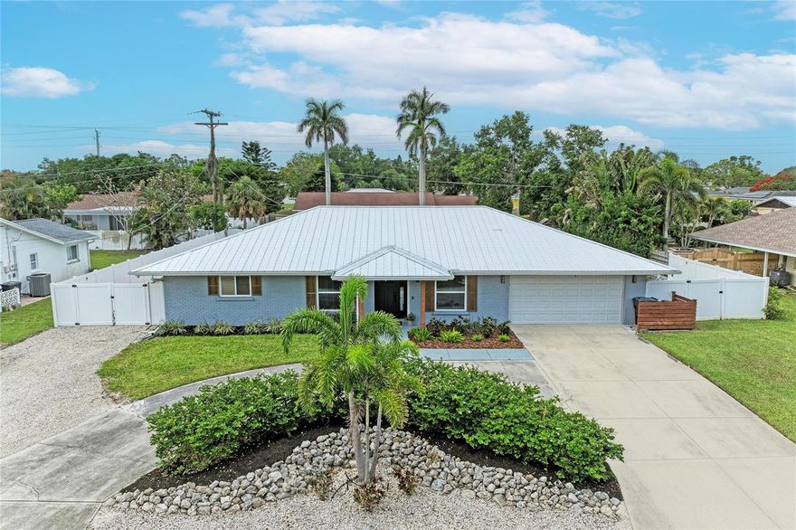 This 3-bedroom, 2-bath + office home with 1,945 sqft in NW Bradenton’s Desoto Memorial area is fully remodeled with a new metal roof, AC, and electrical panel (2021). Inside, this home is filled with designer touches while the outside boasts a large detached workshop, covered back porch, paver patio with gazebo, and RV parking/hookup. This home features an open layout with a dedicated office and upgraded finishes throughout, including LVP flooring, custom accent walls and trim, new interior doors, and updated lighting. The newly remodeled kitchen includes quartz countertops and backsplash, KitchenAid stainless steel appliances, custom plaster vent hood, pot filler, appliance garage, under cabinet lighting, RO water filtration system, and bar seating for four with direct access to a spacious dining area and built-in bar with marble counters. The primary suite includes dual closets with built-in storage system and an en-suite bathroom with walk-in shower. Two additional bedrooms share an updated guest bathroom, and the office offers custom cabinetry, marble counters, and a large picture window for natural light. The outdoor space is designed for flexibility and storage with a large fenced backyard, grilling area, dedicated garden with raised planter beds, and parking for an RV, boat, or multiple vehicles. A standout feature is the large detached workshop, ideal for a home business, hobby space, or additional storage. This home sits high and dry, not in a flood zone but comes storm-ready with impact windows (2014), metal hurricane shutters, and the electrical panel is prewired and setup for a whole home generator to be attached. Additional features in this home include a large laundry room with custom cabinetry, permanent outdoor lighting around front of home for festive lights all year, security cameras and other smart home features. Located just minutes from Robinson Preserve, De Soto National Memorial, the 59th Street Boat Ramp, Anna Maria Island beaches and some of the area’s top schools. Schedule your showing today!