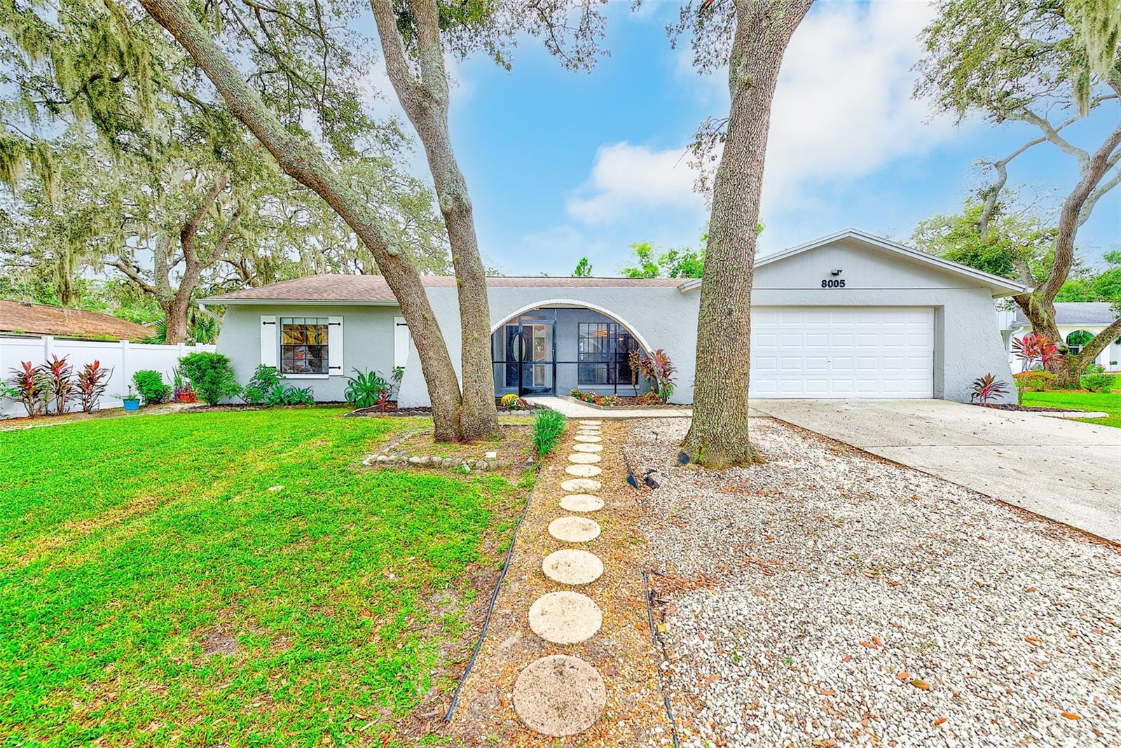 Welcome to this tastefully renovated pool home tucked away on a quiet cul-de-sac, where comfort and style meet everyday living. Featuring 4 bedrooms plus an office, 2.5 bathrooms, and an oversized 2-car garage, this property has been thoughtfully updated inside and out, creating a move-in ready retreat. Fresh landscaping and a charming mosaic-tiled front porch set the stage as you step inside to discover a home designed for both relaxation and entertaining.
The moment you walk through the door, you’re greeted by a sense of openness, thanks to the split floor plan, vaulted ceilings, and luxury vinyl flooring that flows seamlessly throughout. Warm, neutral tones paired with matte black finishes and modern single-panel doors create an inviting ambiance. At the center of the home, the fully renovated kitchen stands as a showpiece, with sleek stainless steel appliances, two tone custom cabinetry, and a large island featuring a quartz waterfall design on both sides. It’s a perfect space to prepare meals, sip morning coffee, or gather with friends while overlooking the cozy stone fireplace in the living room and the sparkling pool just beyond.
To the left of the entry, the guest wing offers three spacious bedrooms, a stylishly updated bathroom, and an additional room ideal for a home office, playroom, or guest space with direct access to the pool deck. On the opposite side, the primary suite feels like a private retreat, boasting vaulted ceilings, a walk-in closet, a linen closet, and a spa-inspired bathroom with a double vanity and a tub/shower combo surrounded by floor-to-ceiling tile. Just off the main living area, you’ll also find a convenient half bath for guests, a large laundry room with sink, and direct garage access.
Step outside and experience Florida living at its finest. The resurfaced and newly tiled pool sits beneath a screened enclosure, surrounded by a spacious refinished pool deck with stamped concrete that elevates the outdoor living experience. Whether you’re hosting weekend barbecues, enjoying cocktails with friends, or simply lounging in the shade of the covered patio, this outdoor space was designed for both relaxation and entertaining. The lush backyard with vinyl fencing and a storage shed completes the retreat-like setting.
Recent upgrades provide peace of mind, including a new roof (2021), high-end HVAC system (2022), water heater (2023), and updated electrical panel. Inside and out, this home has been carefully curated with style and functionality in mind, offering a perfect blend of modern luxury and everyday comfort.
Don’t miss your chance to call this stunning cul-de-sac property your own—schedule a private tour today and imagine the lifestyle awaiting you.