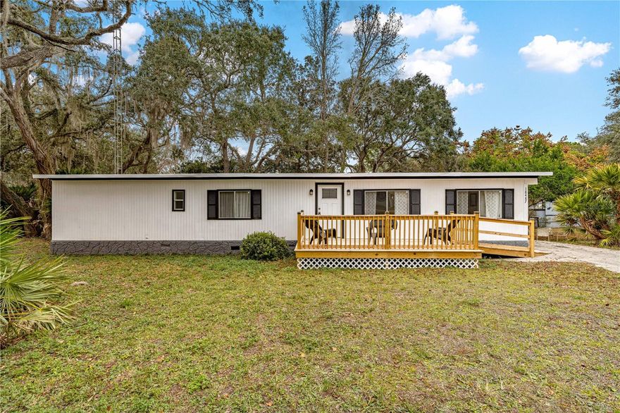 Fully furnished and completely updated, this turnkey home is ready for its new owners to love. Enjoy a bright, open floor plan featuring 3 bedrooms and 1.5 bathrooms. 2025 updates include new plumbing with updated toilets and vanities, brand new hot water heater, washer and dryer, fresh interior and exterior paint, and all-new countertops with a stainless steel double farmhouse sink. The home also features a new front deck with handicap-accessible ramp for added convenience. Step out back to relax in the oversized screened-in birdcage with brand-new screens, ideal for enjoying peaceful wildlife views from your own backyard. This beautifully renovated double-wide sits on its own land with no HOA and no lot rent. Just 18 minutes to Silver Springs State Park, 20-30 minutes to Ocala, 35 minutes to The Villages.