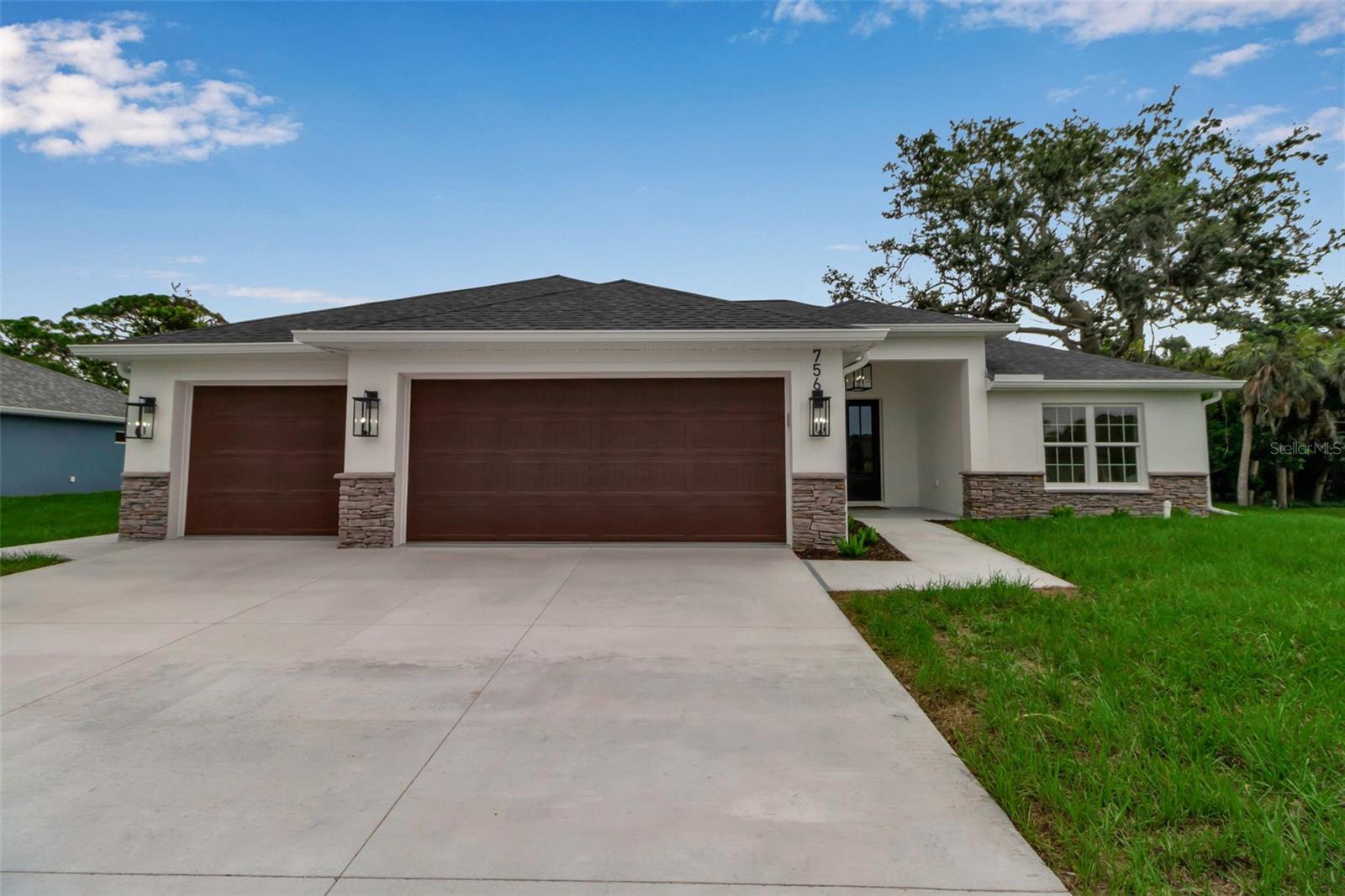 Welcome to the Boca at 756 Citrus Road — a beautiful new build by Blue Water Custom Homes that blends timeless design with modern functionality in the heart of South Venice.
The exterior is warm and inviting, finished in soft stucco with a warm white tone and accented by elegant stone. Clean rooflines, large windows, and a charming covered entry create a refined first impression, while the three-car garage enhances both curb appeal and practicality. The overall look is fresh, coastal, and enduring — a design that feels right at home in Florida’s landscape.
Inside, cathedral ceilings soar over the main living area, filling the home with natural light and volume. The open-concept layout seamlessly connects the great room, dining area, and kitchen — a perfect balance of style and function for everyday living or entertaining.
The kitchen is a true highlight, showcasing slim shaker-style wood cabinetry, a white stone backsplash, and a built-in white range hood for a clean, cohesive look. Black-and-white pendant lights above the island and a coordinating dining fixture add the perfect touch of personality and contrast, striking a balance between trend and timelessness. A generously sized pantry with a pocket door adds both storage and a subtle design flare.
The split floor plan offers both privacy and flow. The primary suite is tucked to one side of the home and features two walk-in closets. A private hall leads to the en-suite bathroom, where a freestanding soaking tub takes center stage, complemented by dual vanities and a walk-in shower with refined tile details. On the opposite side of the home, two additional bedrooms share a full bathroom, designed with the same level of thoughtful finishes.
The laundry room is ideally located between the garage and the main living space, making everyday routines simple and efficient. The three-car garage is a standout feature, offering space not only for vehicles but also for storage, hobbies, or recreational gear.
At the rear, large sliding glass doors open to a covered lanai, extending the living space outdoors. Whether for morning coffee, relaxing evenings, or entertaining friends, this area captures the essence of Florida living.
Set in South Venice, this home offers not just comfort but freedom — with no HOA, no CDD fees, and no flood insurance requirement. Optional membership in the South Venice Civic Association provides exclusive access to a private beach ferry, community boat ramp, and park amenities. Located just minutes from Shamrock Park, the Venetian Waterway Trail, dining, shopping, and Gulf beaches, this home is ideally placed to enjoy everything the area has to offer.
Crafted with care and backed by a 2-10 Home Buyers Warranty, the Boca at 756 Citrus Road is ready to welcome its first owners to enjoy both its thoughtful design and coastal lifestyle.