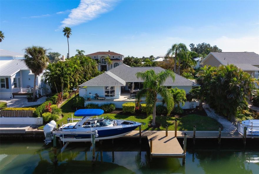 CANAL FRONT IN KEY ROYALE - NORTH POINT HARBOUR WITH COMMUNITY POOL AND TENNIS COURTS. Experience unparalleled luxury in this exquisite and elevated waterfront home. Beautifully remodeled with a NEW ROOF (2025) and turnkey furnished 3-bedroom, 2-bathroom waterfront home, offering nearly 2,000 square feet of luxurious living space and includes a community pool and tennis courts! The home sits at 11 feet elevation and had no flood damage. Located in the highly sought-after North Point Harbour community of Key Royale on Anna Maria Island, this home epitomizes an idyllic blend of elegance and tranquility. Having undergone tasteful renovations, this canal-front gem is fully furnished and move-in ready. It boasts 83 feet of waterfront with a private dock and a 12,000 lb boat lift, allowing you to embark on sunset cruises directly from your backyard into the open water with no bridges obstructing your path. The primary suite is a true retreat with a balcony overlooking the water, complete with a luxurious en-suite bathroom, walk-in closet. Additional bedrooms are generously sized and elegantly appointed. A lovely courtyard patio overlooking the water invites you to enjoy the outdoors and dine alfresco. North Point Harbour residents enjoy exclusive access to the community pool, tennis and pickleball courts, and clubhouse. Additionally, you have the option to join the private Key Royale Golf Club, featuring the island’s only golf course, along with dining and social activities. This home is just a golf cart ride away from Anna Maria Island’s stunning beaches and all its attractions, perfect for embracing the island lifestyle year-round or as a seasonal retreat. This home combines the best of luxury living with the beauty and serenity of a waterfront setting. Don’t miss the opportunity to make this dream home yours.
