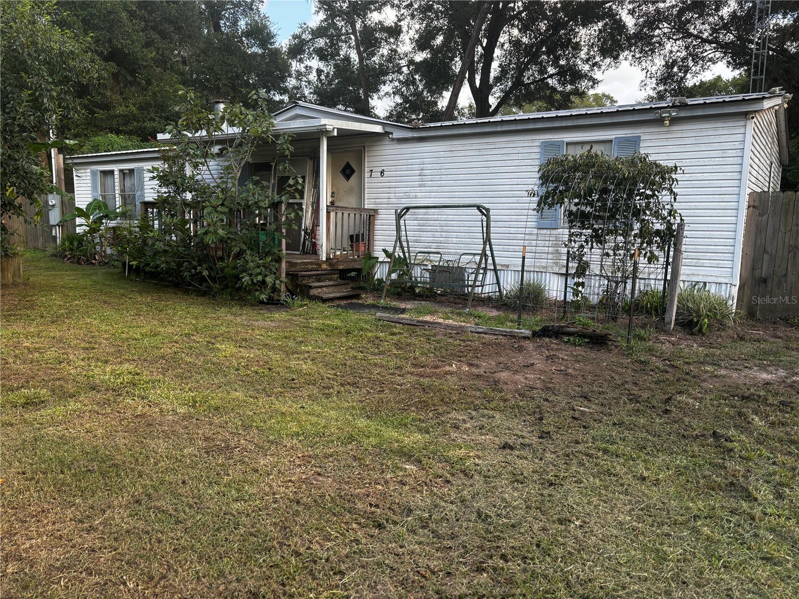 This spacious 4-bedroom, 2-bathroom mobile home is perfect for a large family or those seeking extra room in the desirable King's Park community. Located on a quiet road less than two miles from the World Equestrian Center, this home offers a fantastic opportunity to live the Florida lifestyle with ample space and comfort. While this home offers a solid foundation and generous room sizes, it is being sold AS IS. This means that the home's current condition is reflected in the price and the buyer would be responsible for any repairs or updates needed after purchase. This property boasts a diverse and established fruit orchard featuring peach, lemon, apple, pear, pomegranate, kiwi, and fig trees which are well-suited for growing in this location.