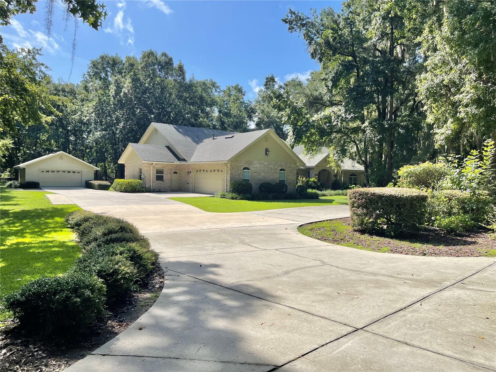 Local Builder’s Personal Masterpiece in NW Gainesville! A rare chance to own this beautifully crafted, custom 4-bedroom, 3.5-bath brick estate built in 2003 spanning over 4,800 sq ft on 3 lush acres—tucked right in the heart of NW Gainesville and free from HOA restrictions! Inside features you will love include: Expansive and versatile floorplan with separate living, family, and dining rooms. Game room with wet bar, two dedicated offices, bonus room, oversized bedrooms with walk-in closets, spacious laundry room and abundant attic storage (above both the main home and garage), New roof just installed in 2025. The Gourmet kitchen has been designed for gatherings: Enjoy double ovens, gas cooktop, microwave, generous cabinet space, quartz countertops, large island, breakfast nook and bar, and a massive walk-in pantry. Luxurious primary suite retreat with two walk-in closets with built-in shelving and a spa-inspired bath featuring dual vanities, jetted tub, water closet, and a multi-head walk-in shower. Flexible Bonus Spaces: The bonus room includes a separate entrance, closet, and access to a half bath and office—ideal for an in-law suite, home business, homeschooling, or a fifth bedroom. Room for All Your Toys: Circular driveway, attached 2-car garage (780 sf), plus a detached 2-car garage (700 sf). Bring your boat, RV, or weekend ride—no HOA means no limits! Utilities: GRU-provided water, electric, and gas complete the picture. Nearby schools of Hidden Oak elementary, Fort Clarke middle school and Buchholz high school. And a short drive to all kinds of shopping, dining and Publix market place.