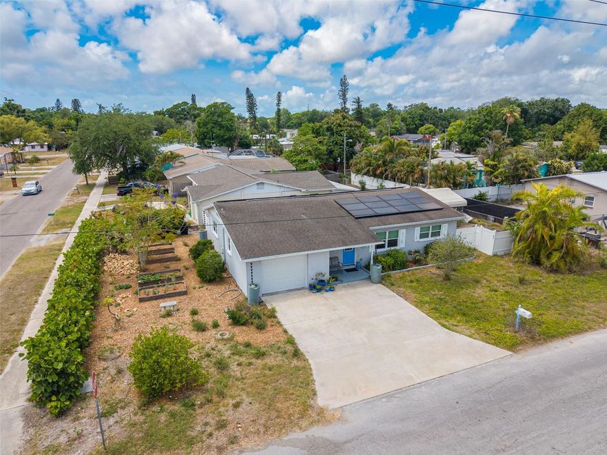 **Eco-Friendly Oasis on a Corner Lot: Updates, Solar Power, and Prime Gulfport Location!** Discover the perfect sanctuary for the environmentally conscious resident in this fully updated, low-maintenance home. This solid BLOCK construction home sits on a desirable CORNER LOT and features 3 bedrooms and 2 full baths, all with beautifully preserved terrazzo floors throughout (except in 1 bathroom). Parking is easy with an oversized 1-car garage and spacious driveway.  Worry-free living is assured with major systems replaced in 2015, including a new ROOF, HVAC, DUCTWORK, ATTIC INSULATION, ELECTRICAL PANEL, and IMPACT windows and doors. A 2018 TANKLESS water heater adds to the efficiency.  Live nearly off-grid thanks to SOLAR PANELS installed in 2016 and 2020, resulting in incredibly low monthly electric bills that often range from $0 to $30.  This property is a dream for gardeners and homesteaders, featuring 4 raised garden beds, rain chains, and 6 rainwater catching barrels. Enjoy fresh produce from numerous fruit-bearing trees and plants, including fig, Meyer lemon, banana, papaya, Thai lime, dragon fruit, pineapple, and blackberries. A chicken coop is also on site.  For peace of mind, the home is located in Flood Zone X, meaning flood insurance is typically not required, and is situated in a Non-Evacuation Zone, approximately 28 feet elevation. The location is unbeatable: enjoy a short bike ride to downtown Gulfport's restaurants and recreation, or hop on the Pinellas Trail just a few blocks away.