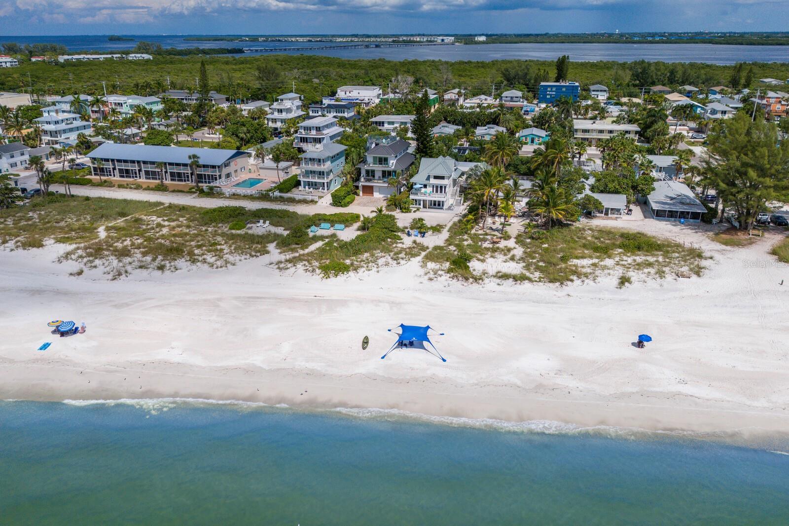 Beachfront home on the sugary sands of Anna Maria Island! Experience the pinnacle of waterfront living with majestic sunsets and breathtaking Gulf views. This beachfront property sits on .23 acres, offers two separate structures, and is zoned as a land-condominium with ability to have four separate condominium units. With 50-by-100 feet of non-buildable lot owned by the owner, the property offers its private beach access. Being sold turnkey, the front house which is closest to the beach, offers a total of four bedrooms and four baths. The downstairs two bedrooms, two baths are ideal for guests and family for space and privacy. The bottom floor is in the process of being repaired due to damage from Hurricane Helene. The upstairs unit is in mint condition and is outfitted with cathedral ceilings, laminate floors, granite kitchen counters and stainless steel appliances. The living area provides panoramic Gulf views and opens up to the exterior deck to enjoy grilling out and listening to the sound of crashing waves to help take away all your worries. The back house has two separate units, upstairs and downstairs, which are ideal for additional guest and potential rental income. The upstairs unit is being rented and has a full schedule for future rental reservations. Each unit offers two bedrooms and one bath. The bottom unit is in the process of being repaired due to damage from Hurricane Helene. This property offers so many opportunities to make it your own. This property is being sold as three parcels, the other two including being #7486900129 and #7486900207. It's all about the view, the beach, the aqua blue waters and sunsets! Schedule your showing today to see this amazing property.