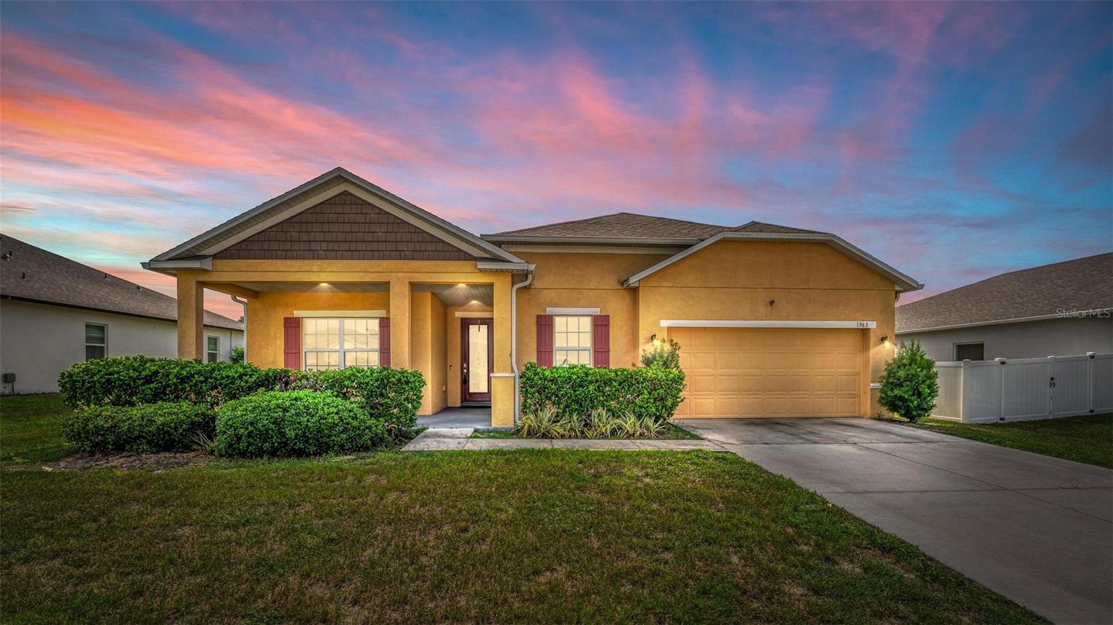 LIKE-NEW 2020 HOME WITH UPGRADES GALORE! Welcome home to this immaculate 4-bedroom, 2-bathroom residence, thoughtfully designed with modern comfort and style in mind. Step into a spacious open floorplan featuring stunning wood-look porcelain tile throughout—beautiful, durable, and easy to maintain. You'll love the large kitchen adorned with granite countertops, elegant tile backsplash, stylish pendant lights, premium 42-inch solid wood cabinets with soft-close hinges, and an oversized breakfast bar with additional seating—perfect for entertaining family and friends.
The spacious primary bedroom, featuring a lovely tray ceiling, is the ideal retreat to unwind after a long day. The on-suite bathroom boasts dual sinks, a spacious walk-in shower, and a generously sized walk-in closet. 4th bedroom can be used as a large den, perfect as a home office or bedroom with the addition of a closet or armoire. Relax outdoors on the expansive screened-in lanai overlooking the private backyard, or unwind on the charming covered front porch. An oversized garage offers ample space for vehicles and additional storage. Meticulously cared for, this home feels brand new and is move-in ready. Bonus: Seller will consider selling select furnishings! Don't miss this opportunity—schedule your showing today!
