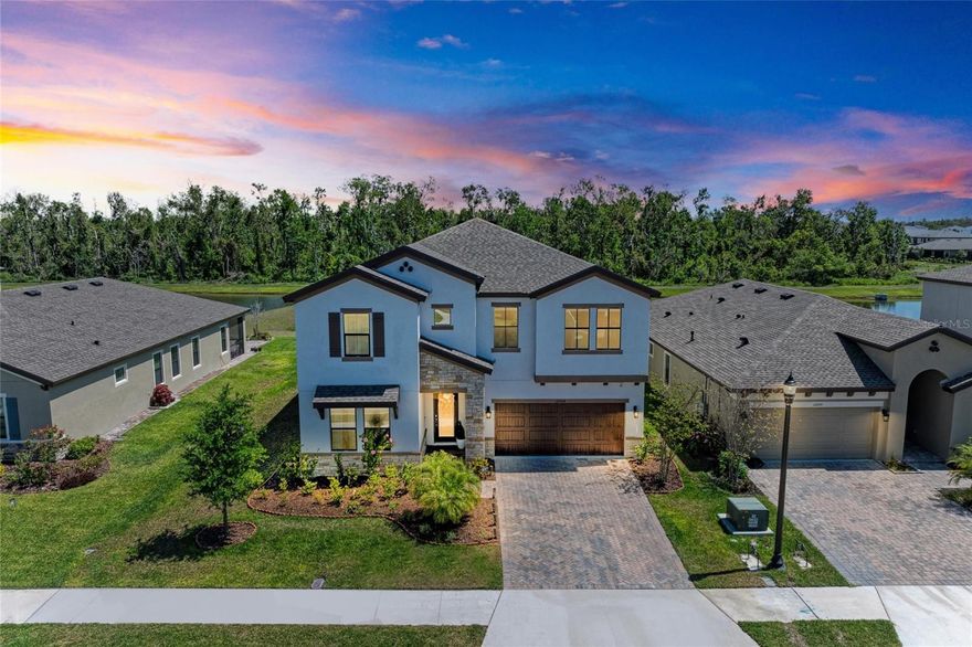 Welcome to Your Dream Home—A 2022 Luxury Masterpiece with Lake and Conservation Views Experience the perfect blend of comfort, style, and sophistication in this beautifully crafted 5-bedroom, 3-bathroom home, offering 3,419 sq. ft. of thoughtfully designed living space. Located in the desirable Crosswind Point community, this home is a true haven, thoughtfully designed for both elegance and everyday living. The spacious layout features five inviting bedrooms, including a serene owner’s retreat with a cozy sitting area, a generously sized walk-in closet, and an ensuite bath designed for relaxation—complete with a custom vanity, walk-in shower, and separate water closet. The open-concept living area creates a seamless flow between the grand living room, dining space, and the chef-inspired kitchen, all with easy access to the outdoor lanai, perfect for casual lounging or entertaining. Warm, rich plank tile flooring extends through the main living areas, adding a touch of elegance and making the space feel both inviting and refined. The kitchen is a true showstopper, with 42” cabinets, built-in features, soft-close drawers, and crown molding, paired with sleek Quartz countertops, a subway tile backsplash, and premium appliances—including a gas range and a large walk-in pantry. For those who love to entertain or need extra storage, the Butler’s pantry is truly one of a kind. It’s equipped with custom cabinetry, a beverage fridge, a work station, and even a stylish cherry-red fridge, alongside a dedicated prep countertop—perfect for both big gatherings and quiet nights in. The practical touches don’t stop there. Adjacent to the oversized (20’ x 23’) garage is a convenient drop-off station for coats, bags, and shoes, helping keep everything organized. The spacious laundry room is equipped with a utility sink and a Samsung smart washer/dryer set, making everyday chores a breeze. This home is full of thoughtful upgrades, including custom landscaping, paver pathways, screen enclosures, elegant lighting, and ceiling fans throughout. Every corner of this home has been designed to bring comfort and warmth. The expansive lanai is an outdoor oasis, featuring a fully equipped alfresco kitchen and offering peaceful views of lush conservation land and a tranquil lake. Whether you're enjoying a quiet morning with breathtaking east-facing views or entertaining loved ones, this outdoor space is sure to become a favorite retreat. More than $53,000 in additional upgrades include a gorgeous French-door office with custom built-ins and lighting, luxurious vinyl plank flooring in the guest room, upstairs, and stairs, custom blinds, built-in closets in the secondary bedrooms, and beautiful pendant lighting in the kitchen. The garage also features an epoxy-coated floor for easy maintenance. Crosswind Point offers the perfect balance of peaceful living and easy access to everything you need. Shopping, dining, and entertainment are just a short drive away, with downtown St. Petersburg and Sarasota only 30 minutes away, and downtown Tampa a quick 40-minute drive. Exclusive community amenities include a pool, cabana, pocket parks, and scenic pond views—making this the perfect place to call home.