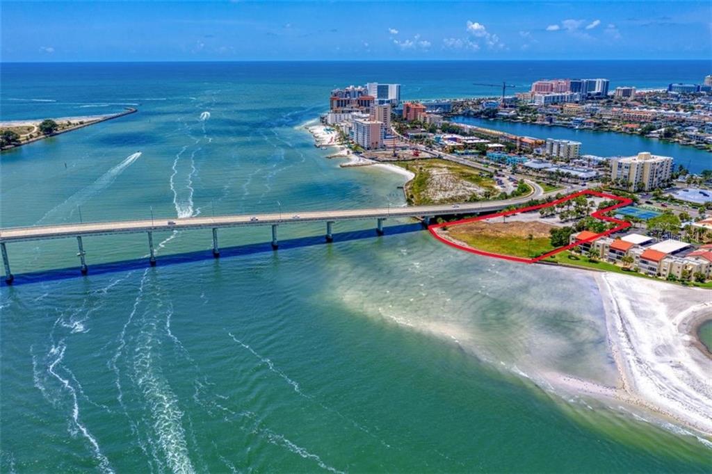 ONE OF THE LAST VACANT AND BUILDABLE LOTS ON WORLD-FAMOUS CLEARWATER BEACH. This is an opportunity to develop 3.20 Acres MOL into the next destination resort, condominium or world-renowned restaurant. Recently approved for luxury condominium units.
Situated at the base of the Sand Key Bridge and surrounded by shopping and dining, this prime waterfront location offers an expansive 300 feet of seawall. There’s virtually 180 degree sweeping views of the intracoastal waterway, Clearwater Pass and the Gulf of Mexico from this southern facing location. Conveniently located near the Sand Key Bridge and the Memorial Causeway to easily access to the main land—and the last trolley stop before Sand Key. Only 30 minutes to Tampa International Airport! The location has been part of the City of Clearwater’s Beach by Design masterplan and is the last parcel in the City’s Beach Community Redevelopment District on the southern end of Clearwater Beach. A top attraction for locals and visitors, Clearwater Beach is consistently voted a top beach in Florida and the U.S. The Clearwater Marine Aquarium is just minutes away and popular Clearwater Beach are awaiting the next great addition to Florida’s Gulf Coast.