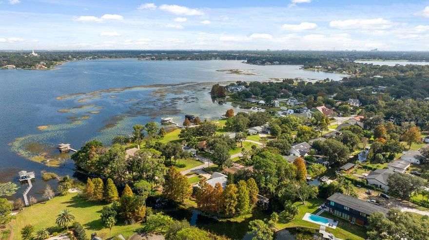 CANAL FRONTAGE ON 2 SIDES! Extremely RARE in the TOWN OF WINDERMERE, a single story 3/2 in a CUL-DE-SAC, on a PAVED STREET with a DOCK and CANALS ON 2 SIDES giving DIRECT ACCESS to LAKE DOWN AND WASEON BAY and the ENTIRE BUTLER CHAIN BEYOND. This lovingly maintained home is move-in ready, ready for your personal touches, or the ideal lot for your waterfront dream home. Extensive landscaping with abundant flowering plants and a covered front porch provide a warm welcome to this spacious ranch home. A foyer divides the kitchen and living spaces from the bedroom wing. The kitchen features solid surface countertops, wood cabinets and a breakfast nook with views of Lake Down. A large formal dining room and living room offer ample space for hosting holidays and entertaining family and friends. An absolutely enormous family room with wood plantation shutters is anchored by a beautiful wood burning fireplace and views of the canals. The spacious bedrooms feature vaulted ceilings and California closet organizers. The primary suite has an en-suite bathroom and sliding doors to a large, covered patio in the rear. The primary bath and hall bath have been beautifully updated. The large rear and side yards are also heavily landscaped with wood paths, mature cypress trees and unparalleled views of the canals. There is a COVERED DOCK in the rear. This is a NATURAL GAS home with hookups for the GRILL, DRYER and TANKLESS WATER HEATER. One of the 2 car garage bays currently houses a SAUNA. ROOF REPLACED in 2019, A/C in 2016. This is what Windermere living is all about - a large cul-de-sac waterfront lot on the Butler Chain of Lakes and a short distance to the shops and events in downtown Windermere.