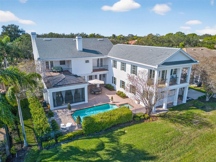 Experience timeless elegance in this meticulously maintained, custom-built traditional pool home, perfectly positioned on the 9th hole of the prestigious Bayou Club Estates. From the moment you enter, a grand curved staircase and soaring two-story foyer set the tone for sophistication, complemented by rich hardwood floors throughout. The home offers formal living, dining, and family rooms, each enhanced by gas fireplaces, plus a charming private bath tucked beneath the staircase.  Enjoy the sunroom’s striking black-and-white marble floors and arched windows, or gather in the chef’s kitchen featuring stainless steel appliances and an impressive 440-bottle, climate-controlled wine room. A second staircase off the kitchen leads to a stunning new addition (2024) boasting two bedrooms, two baths, vaulted ceilings, a private balcony, and a laundry area. Upstairs, you’ll find three additional bedrooms, three baths, and an office/den. The luxurious master suite offers serene views of the pool and golf course, French doors, a cozy sitting nook, and a spa-like bath with double vanities, soaking tub, walk-in shower, and expansive closet.  Recent upgrades include a brand-new tile roof (2025, $100K+), Trane AC system (2019, $13K), and the 2024 addition ($180K), located over the garage w/2beds/2baths vaulted ceilings, and a balcony too. Outdoors, your private oasis awaits with a heated pool and spa accented by lionhead fountains, plus a spectacular shade pavilion (2021, $128K) featuring a natural gas fireplace and private "pool" bath. The oversized lot (.34 acres) includes a long driveway and a side-entry three-car garage.
Bayou Club Estates is a golf cart community with 24/7 gated access, a Tom Fazio-designed 18-hole private golf course, and with an “Old Florida” ambiance with oak-lined streets, lakes, and a nature preserve.  Ideally located in central Pinellas County, just 12 miles from Downtown St. Petersburg and 7 miles from Gulf beaches.  No Flood Zone!