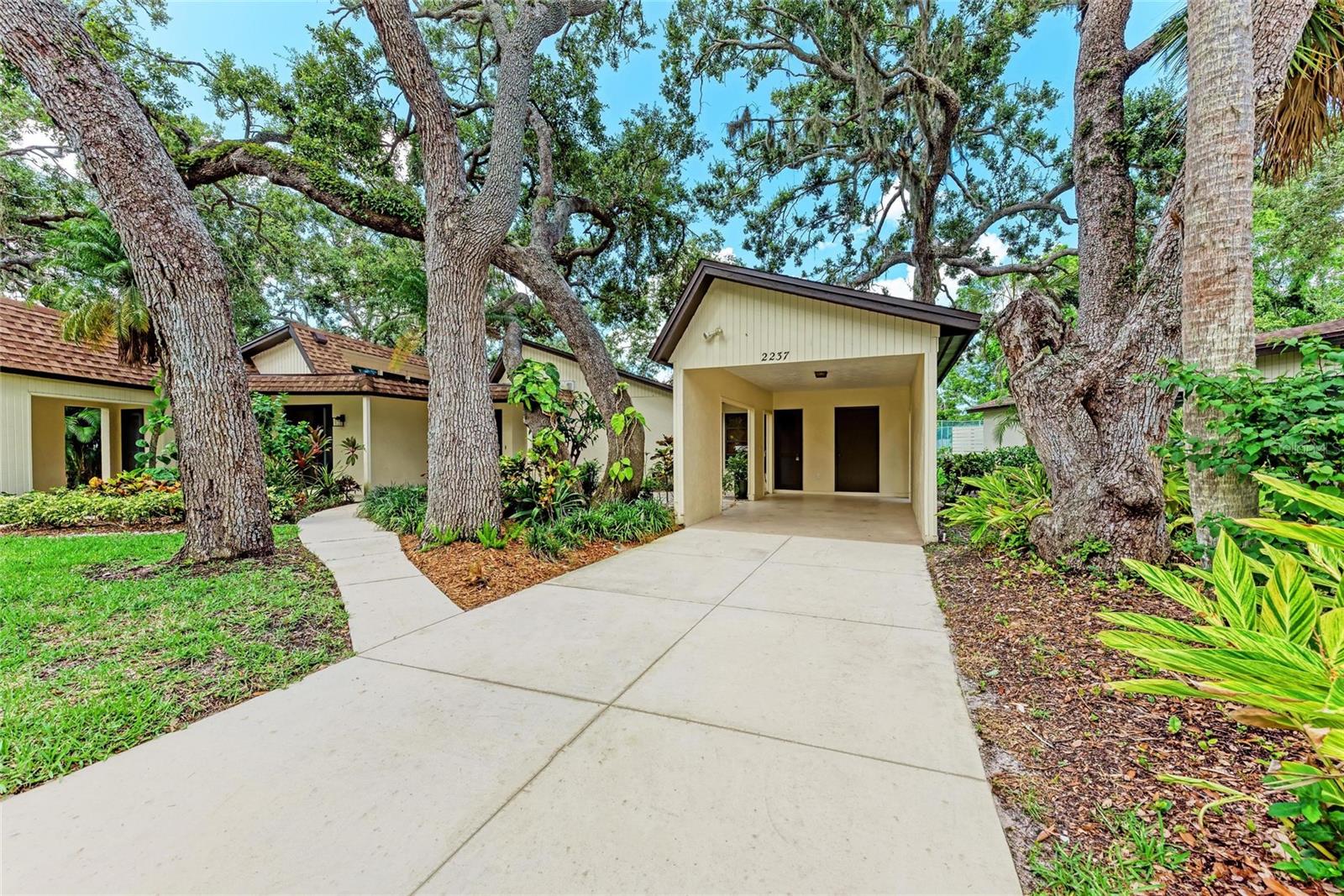 Upgrades galore in this stunning 2 bedroom 2 bath villa. Convieniently located near the pool and tennis / pickleball courts in the desirable neighborhood of Woodside Village East. Beautiful Travertine Marble floors throughout the unit. New HVAC unit (June 2025), updated bathrooms with generous use of stone. The spacious living room has vaulted ceilings, crown moulding and flows into the charming Florida room with an abundance of natural light. Updated Kitchen is completely open to the living space with granite and quartz counter tops with new dishwasher and refrigerator. Master bedroom was modified to close off the bathroom and create an alcove perfect for use as an office workspace. Walk in closet and sliders open to private patio. Spacious second bedroom with large walk in closet. Beautiful front garden with tiled area, great for outdoor entertaining. Dont miss this one, easy to show.