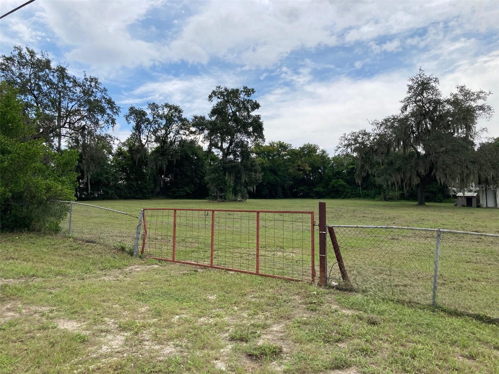Beautiful corner lot for a new house at 100' x 135' so plenty of space to include the city required building setbacks! Great central location in a developed residential neighborhood. Lot is mostly cleared, with some trees remaining along the Claude Holmes Sr Road side that provide much privacy for a new house facing 2nd St. Zoning is residential for houses but please confirm all details for construction with the Haines City building department. All offers are to have already completed their due diligence, owner will not accept any offers that include a due diligence period. Please note that there is tie tape on the front fence to indicate the Southern lot line and a stake in the yard with tie tape that aligns with that. The South lot line does not align with the chain link fence. Public water is available on site. Public sewer is not available on site. There is a photo of the title company information that I use for most of my closings.