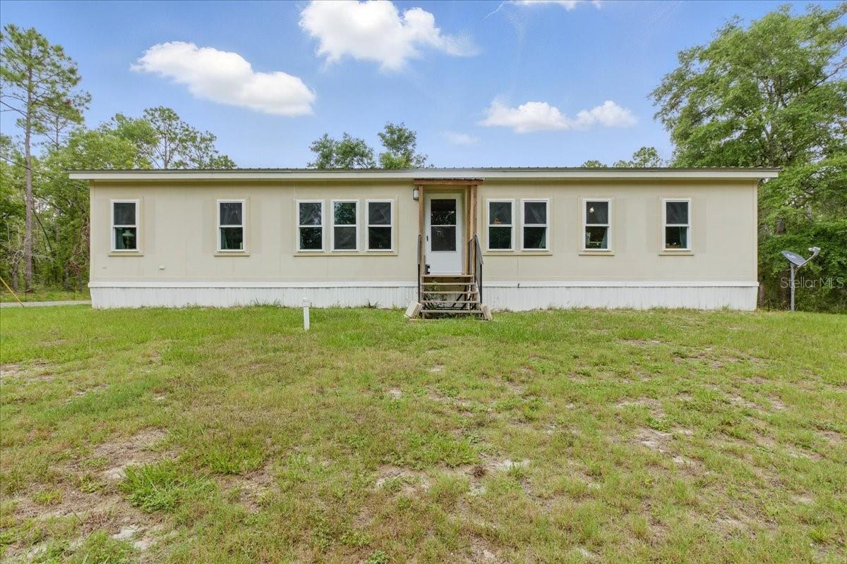 Custom 3BD/ 2 BA Horton home on 2.23 acres offers privacy and lots of storage options. As you enter through the automatic gated entrance you come by the naturally hardwooded area of the property into the cleared area around the home that gives ample yard space in front and back. A well kept home boasts many upgraded features such as newer luxury vinyl plank flooring throughout, newer french door stainless refrigerator, and new ADA toilets and faucets. The entire home has tape and textured drywall finish. The nice open layout of the home makes it feel more spacious than 1792 sf. The corner stone fireplace adds a down home atmosphere as do the wood cabinets in the kitchen. The owners have maintained the home to every extent. The home has been leveled, all windows have been replaced with Window World double hung, double pane windows. These windows carry a warranty that can be transferred to the new owner. The HVAC system is less than 5 yrs old and all ducts were cleaned and sealed when it was replaced. The new system also was upgraded to include a UV light to promote healthy air. A metal roof was installed in 2019 and will last for many more years. Another improvement you will appreciate is the covered porch off the back entrance and both entrance doors are newer insulated residential doors with storm doors as well. Outside you will find a storage place for all of your needs! A large metal carport has a closed end and sides to protect your vehicle or boat. Another large metal 25x30 workshop on concrete can also accommodate boat, tractor, vehicle, UTVs, mowers, etc or can become an awesome workshop. Lastly, another metal utility building has a asphalt ramp up to it and it would make a great 'she shed', office, bunkhouse, or simply additional storage for your belongings. For added convenience, the owners have paved a large portion of the driveway which is a pleasant surprise. A large portion of the property is fenced for pets or kids. Come see what this country charmer has to offer! It does not disappoint!