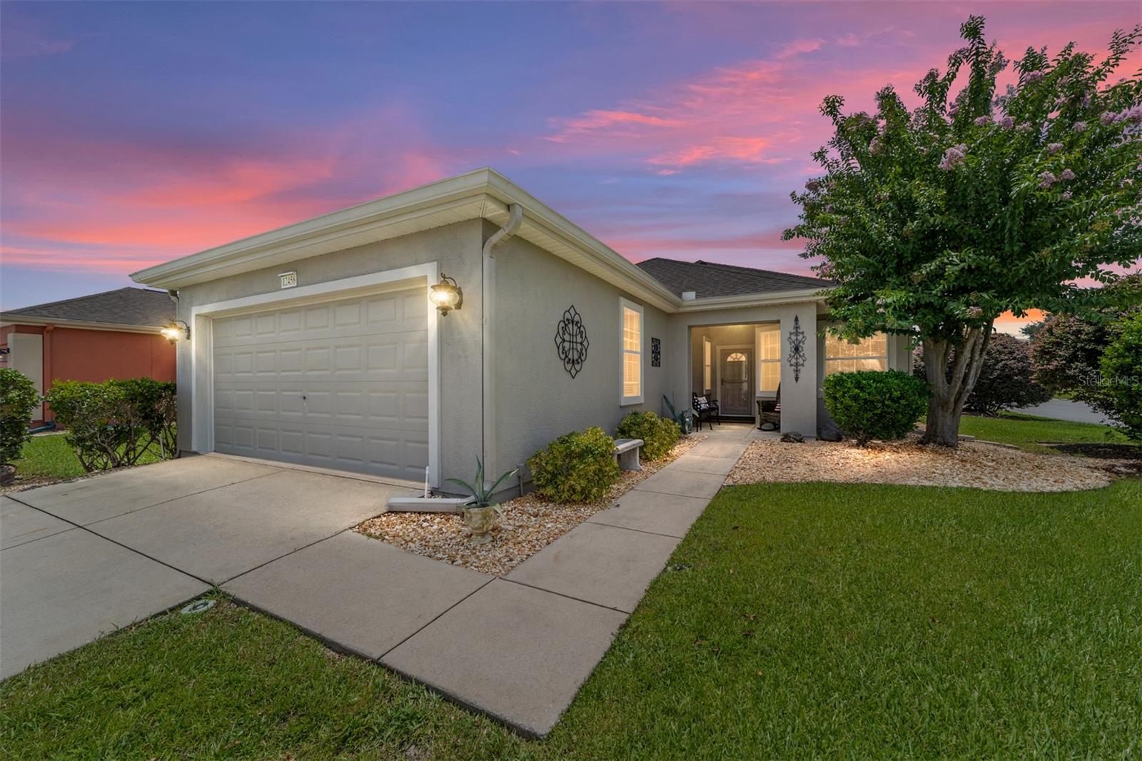 Ever-Popular Kingston Patio Model Near Amenities!
Ideally located just a short stroll from the fitness center, indoor pool, softball field, walking trails, horseshoes, and more, this well-maintained Kingston Patio model is ready for its next chapter. Gently used by snowbirds for only half the year, this home offers smart upgrades and a comfortable floor plan designed for easy living. The kitchen features oak cabinetry, white appliances, recessed lighting, and a reverse osmosis system, along with a spacious dining area perfect for daily meals or entertaining. The open-concept living and dining rooms flow seamlessly into the enclosed, climate-controlled lanai with tile flooring—ideal for year-round enjoyment.You'll appreciate the extra insulation added for increased comfort and reduced utility costs. Flooring includes Berber carpet in the bedrooms and main living area, and vinyl in the kitchen, walkways, and both bathrooms. The primary bedroom boasts a beautiful bay window, bringing in natural light and additional space. An inside laundry room leads to the extended 27-foot garage, offering plenty of room for vehicles, storage, or a workshop. Major updates include a new roof (2021), HVAC (2018), and a newer hot water heater. Located in the heart of Del Webb Spruce Creek, where resort-style living awaits! Enjoy 36 holes of championship golf, pickleball, tennis, three heated pools (including one indoors), a dog park, RC track, and hundreds of clubs and activities for every interest. Make plans to see this fantastic home today!