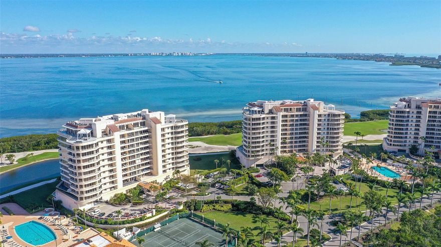 An incredible opportunity as all special assessments have been paid in full by Seller! Furnishings included! Move right in and begin your luxury resort lifestyle TODAY and enjoy this season in an updated, 3 full bedrooms 3.5 bath residence highlighting sweeping Sarasota Bay and City views from every room. The oversized kitchen has been redesigned and completely opened up to the gathering & dining area for effortless entertaining and water views. A marble wall with fireplace, TV and wine bar add to the relaxed atmosphere. The private main bedroom rests in seclusion with 2 separate baths and 2 fitted closets. Designed for privacy the guest room has an ensuite bath and walk-in fitted closet.  Currently furnished as an office with a sleep sofa, the third bedroom with a double door entrance has its own fitted walk-in closet and full bath. The secure resident-only elevator takes you from 2 under-building side by side parking spaces directly up into your own private elevator foyer.  A massive wraparound terrace with walls of sliding doors span the perimeter of this almost 3,000 A/C Sq. Ft. residence. Amenities include 24/7 guard gated entry, on-site management, state-of-the-art fitness center, club house, two large, heated swimming pools, two spas, two tennis courts, gorgeous walking grounds, and biking right outside the gate plus membership to the Bay Isles Beach Club on the Gulf of Mexico with gated entry, private parking, an on-site attendant, covered entertaining area, restrooms, changing rooms, covered picnic tables, barbecue grills, and volleyball court.