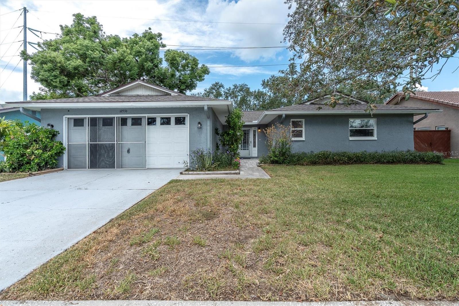 Welcome to this exceptional value in the desired subdivision of Avon Ridge! Whether you're looking for a full-time residence, a seasonal getaway, or a smart investment opportunity, this private oasis checks every box. Just minutes from Indian Rocks Beach, this charming home welcomes you with an open floor plan, tile flooring throughout—where luxury upgrades, energy efficiency, and Florida charm unite. This stylish 2-bedroom, 2-bath retreat boasts a brand-new roof (2025) and fully paid-off 5kW solar panels, offering significant value and peace of mind for years to come. Inside, the open-concept layout is a showstopper, featuring wide-plank luxury vinyl flooring, designer finishes, and a cozy natural stone fireplace. The fully remodeled kitchen shines with white shaker cabinetry, luxury quartz counters, dramatic chevron backsplash, Whirlpool stainless steel appliances, and gold-accent hardware—all set beneath a custom wood-inlay ceiling with striking lighting. The sun-filled Florida room adds versatility for work, wellness, or play, with panoramic windows that bring the outdoors in. Photos show the home both furnished and unfurnished to highlight layout flexibility and lifestyle potential. Furnishings are for staging purposes only and not included in the sale. The private primary suite offers dual walk-in closets and a spa-style bathroom with dual shower heads and sleek tilework, while the spacious secondary bedroom adapts beautifully to any lifestyle need. This home sits in Flood Zone X and remained high and dry during the 2024 hurricanes. Step out to a covered patio and spacious, fenced backyard—perfect for future pool plans, gardening, pets, or weekend entertaining. A rear gate offers convenient access to the Pinellas Trail, with nearby scenic parks and lakes for outdoor adventures. Enjoy quick trips to Walsingham Park, the Florida Botanical Gardens, and Indian Rocks Beach. Nestled off main roads in a quiet neighborhood, you're just minutes from Largo Mall, Seminole City Center, golf courses, dining, and top-rated beaches. With easy access to major medical facilities and airports—including Tampa International and St. Pete-Clearwater—this property is priced to sell and brimming with possibilities. Schedule your private tour today!