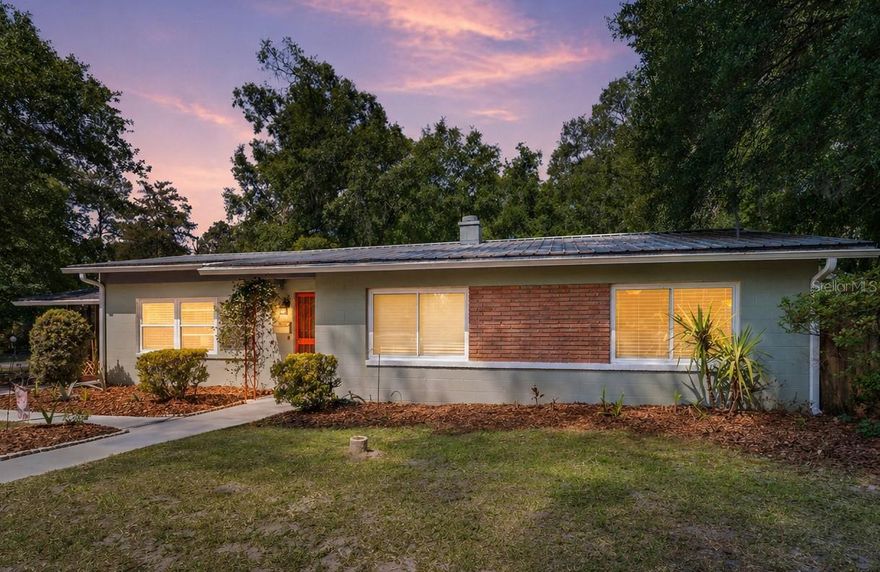 Set on a large corner lot just east of the Historic Duckpond area, this bright and airy 1950s home offers flexibility and value that’s hard to find. With 5 bedrooms and 3 full baths, the standout feature is a fully integrated 2-bedroom, 1-bath rear wing with its own private entrance (and HVAC system)—well suited for extended stays, guests, or income-producing potential.

Inside, natural light fills the main living spaces. The family and dining area centers around a wood-burning fireplace with updated brick, blending original character with clean, modern touches. Key updates include double-pane windows, updated kitchen, a metal roof, a tankless water heater, new gutters w/ leaf guards,—improvements that matter.

Step outside to a newer paver patio and a completely separate, custom studio, ready for work, workouts, creative projects, or a quiet retreat.

Location ties it all together: approximately 1.2 miles to The Hippodrome, about 2.5 miles to University of Florida, 3 miles to UF Health Shands Hospital, and 3.5 miles to Malcom Randall VA Medical Center. A rare combination of space, flexibility, and proximity in one of Gainesville’s most established areas.  Video Tour: https://youtu.be/xuhp_Kz8PPI