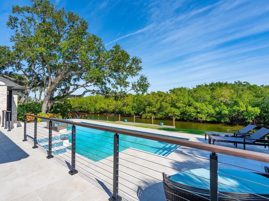 A luxurious waterfront retreat; welcome to paradise. Nestled in a coveted Siesta Key neighborhood just a leisurely .6 miles to the world-renowned Siesta Beach, this stunning home epitomizes coastal living with its direct bay boating access. Built for refined comfort and entertaining, this home was completely transformed in 2017. High clerestory windows allow ample morning light under a 19-foot wood-beamed vaulted ceiling. A sculpted wood wall anchors the living room, accentuated by the electric fireplace, adding to the casual contemporary elegance. The heart of the home, the spectacular kitchen, features vaulted shiplap ceilings, custom rift oak cabinets, quartz counters, Bosch appliances, a wine fridge, and an oversized island, perfect for gatherings. The first floor boasts three bedrooms, two with en-suite baths, showcasing exceptional finishes, while a third doubles as an office with a loft. A large, fully outfitted laundry room adds convenience. Ascend the custom-designed wood staircase to the private primary suite on the second floor, offering a sitting area and a covered balcony to relish the water view, beautiful sunrises, and balmy bay breezes. The en-suite bath is a true sanctuary offering a coffee bar, dual sinks, a soaking tub, a glass-enclosed steam shower, and ample storage. Descend the staircase to the first level and step through impact glass doors to the covered lanai overlooking the oversized, sparkling pool surrounded by porcelain pavers for seamless indoor-outdoor living. The outdoor kitchen, wood tongue-and-groove vaulted ceiling, motorized retractable insect screens, and lush tropical landscaping create an inviting oasis. Enjoy direct access to Sarasota Bay and the Intracoastal Waterway from your Trex dock for endless boating, kayaking, and paddleboarding adventures. Meet dolphins and manatees up close and be mesmerized by the vast array of beautiful waterfowl. This meticulously designed home seamlessly blends luxury, comfort, and waterfront living, offering a rare opportunity to own a slice of paradise in Siesta Key. Don’t miss your chance to experience the epitome of island living. You can have it all - mere steps from the open bay and close to the powdery white quartz sands of Siesta Beach and the azure waters of the Gulf of Mexico. Enjoy the convenience of being close to Siesta Village, offering an array of dining, shopping, and entertainment options. Only 15 minutes to the mainland to experience vibrant downtown Sarasota's dining, shopping, and entertainment offerings. Bedroom Closet Type: Walk-in Closet (Primary Bedroom).