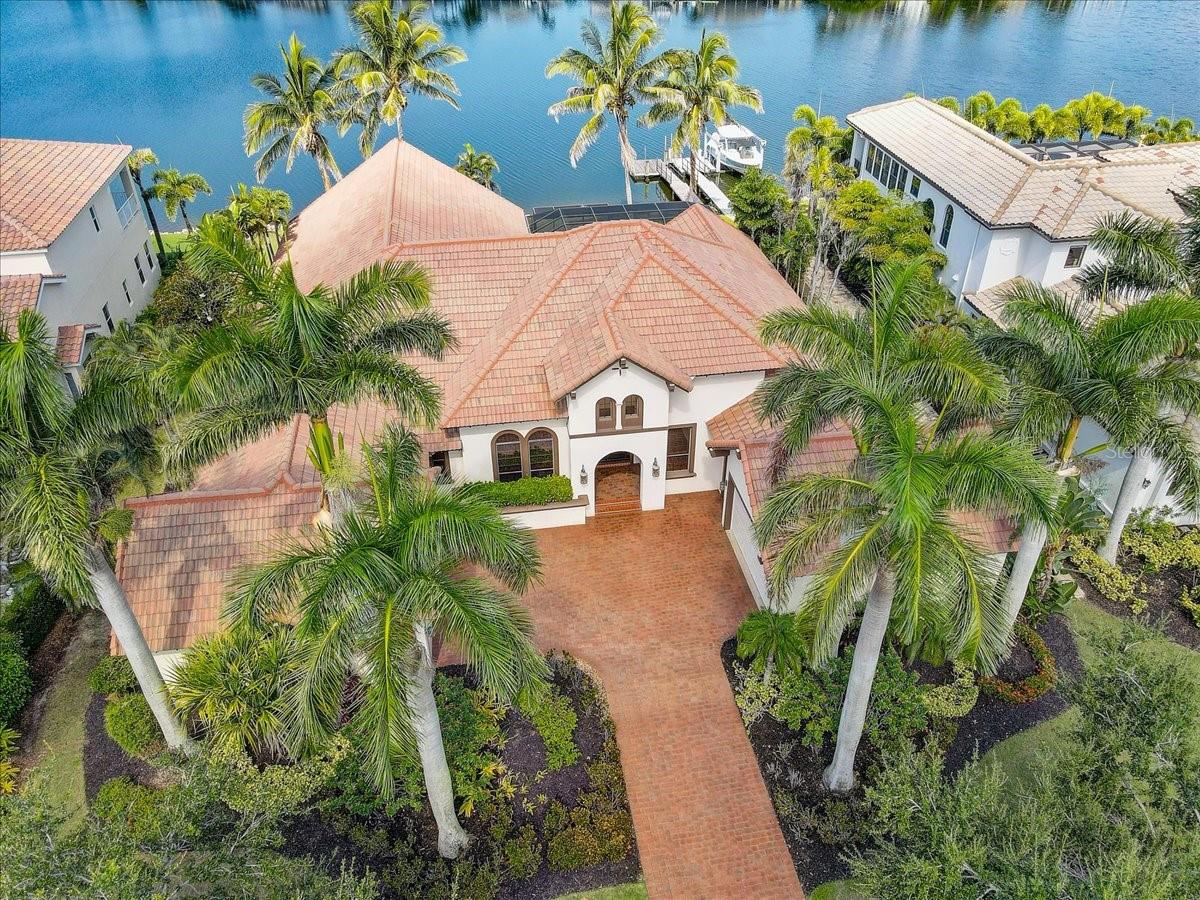 Enjoy Luxury Coastal living in a Spanish Mediterranean executive custom home. This home is for those who appreciate picture perfect water and pool views from multiple angles and rooms. The John Cannon design team created a mariner's dream with a private deep water dock on a western facing lot providing sunset water views. The regal interior features 4 bedrooms, a separate office/flex space plus 3 full and 2 half baths. The media room has a double-sided fireplace and access to the pool! Everyone will love the Audio/Video system that extends throughout the home. The Chef's Kitchen boasts a Wolf gas range with grill and griddle, Granite Countertops, Island with Bonus Sink, SubZero 632 Fridge, Fisher & Paykel dual drawer dishwasher, and a Custom Hidden Large Pantry. The primary wing features a large walk-in shower with garden tub and a record amount of closet space with TWO custom walk-in closets. The primary bedroom has a private sitting area with beautiful wood floors overlooking the pool area and feels private and quiet. This home has premium finishes with crown molding and tray ceilings along with tasteful built ins for style and storage, custom lighting and custom cabinetry. While the inside is spectacular, the outdoor pool area is a perfect place for relaxation with an outdoor kitchen featuring a Napoleon grill, Sink and an AC Pool Bath with convenient access to the rear of the property. The Infinity Pool has plenty of self-clean features, waterfall, temperature controls, heated spa, and plenty of room on the paver deck for entertainment and fun! Mirabay offers resort amenities, including a beautiful community pool/spa, lap pool, splash pad, three playgrounds, fishing, boat docks with deep saltwater access and clubhouse. There is also a fitness center, cafe with full service bar, pickleball, basketball, tennis courts and plenty of walking trails and so much more call for a tour today!