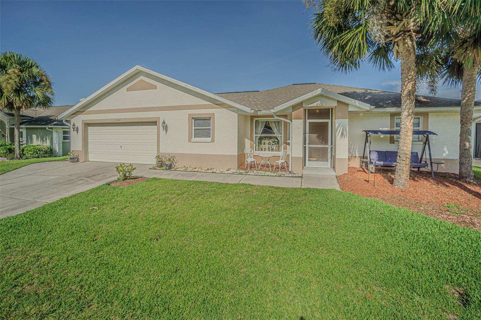 Live the RESORT Lifestyle in this updated 2-bedroom, 2-bath home located in the highly sought after 55+ gated community of Tampa Bay Golf & Tennis Club! Situated on an oversized lot, this modified Riviera model offers a thoughtfully expanded great room floor plan and a rare side-entry golf cart garage. The home boasts cathedral ceilings, double-pane windows, and a fully enclosed Florida room with vinyl windows... perfect for enjoying your morning coffee or entertaining guests overlooking your private backyard. Screened front entry welcomes you and once inside you will be greeted with a Light, Bright, OPEN floorplan with Cathedral ceilings. The U-shaped kitchen offers a window over the sink overlooking the front landscape, white cabinets with contrasting drawers for added storage, breakfast bar OPEN to dining area plus a closet pantry. All appliances are included... Stainless steel refrigerator, smooth top range, dishwasher, counter microwave, washer/dryer, as well as all window treatments and upgraded ceiling fans. The new garage door opener comes with two transmitters for added convenience. Split bedroom layout ensures privacy for both homeowners and guests with the cathedral ceiling, SPACIOUS Great room in the center to make entertaining a breeze! Great room and spacious primary suite features sliding glass doors to enclosed lanai, with spacious walk-in closet and a bath ensuite off the primary bedroom, featuring a walk-in shower, while the guest bath offers a tub/shower combo. Modified Rivera plan includes an inside utility closet off the kitchen instead of the washer and dryer in the garage. Major upgrades include a brand NEW ROOF in August 2023 with a limited lifetime warranty, newer A/C unit (August 2023) with a 5-year warranty plus a Culligan whole-house water softener system (owned, not leased). Additional highlights include gutters, an extra-wide driveway, screened-in entry and lanai areas under roof, creating cross breezes and wonderful outdoor living space. This Move in Ready property offers fantastic value, with a lot large enough to add your own private pool. Residents of Tampa Bay Golf & Tennis Club enjoy access to two championship golf courses, 15,000 sq. ft. clubhouse, heated community pool, full-service restaurant and bar, fitness center, library, billiards, shuffleboard, poker tables, two dog parks, and a vibrant calendar of social clubs and activities including dance lessons, painting, crafts... in addition to planned onsite entertainment, dinner shows and travel excursions. This is your opportunity to enjoy RESORT SYTLE living in a tranquil yet active community—perfect for downsizing or retiring in comfort. Located just North of Tampa with easy access to Ocala, Orlando, Tampa, Lakeland, Wesley Chapel, International airports or the beaches! CALL TODAY!