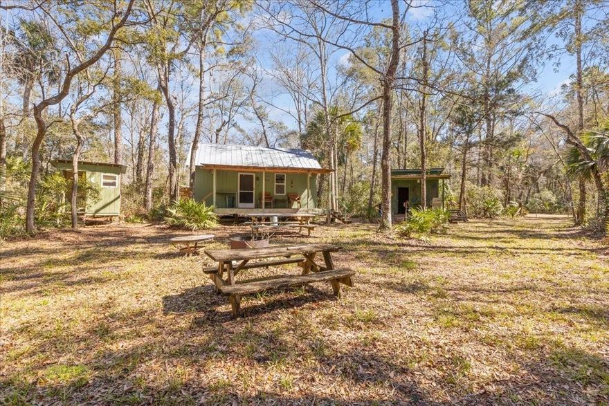 Prime Recreational Hunting Land With Camp!! This 86+ Acre property has lots to offer, main Cabin has a small Kitchen, Dining Area, Two Bump Bed sets, A/C and Covered Front Porch, Bunkhouse Cabin with Two Bump Bed sets, Seating & Table Area, A/C with Front & Side Porch, Full bathroom with Shower, Workshop/Generator House , Hunting Cleaning Station, Small Shelter for Camp Equipment etc. All Structures have a metal Roofing. There are Lots of trails and feeding plots throughout the property with hunting stands and feeders, 80/20 High/Low Land. Bring your Family & Friends Hunting Gear four wheelers, because there is all year around hog hunting and much more! There are 26 miles of road systems throughout Tiger Island that you can trail ride but no hunting off roads. Tiger Island is a 7,000 acre sportsman hunting & recreational community with gated entries, and each owner is given a key that unlocks both the Buck Trail (North) entrance & Clayton Road (South) entrance. This community provides outstanding recreational & hunting opportunities. LOADED WITH DEER, TURKEY, WILD HOG, BEAR, & OTHER Wildlife! This property is located just minutes from THE LOWER SUWANNEE REFUGE THAT CONSIST OF APPROX. 53,000 ACRES and Short drive to Historic Cedar Key fishing village, offering waterside dining on the Gulf of America, boat ramps for saltwater fishing, Beach area for family swimming w/adjacent park, walk along the boardwalk on the Gulf, explore the small town shops, visit the small airplane Airport, participate in public dock fishing, all providing that fishing community experience! Just minutes to Fowlers Bluff boat ramp & Treasure Camp Restaurant on the Suwannee River, 8 Miles to Shell Mound, Only 20 minutes to Chiefland w/ Walmart, restaurants, shopping, & local springs. Gainesville and Ocala approx. 30 minutes. Call for a showing today By Appointment Only!