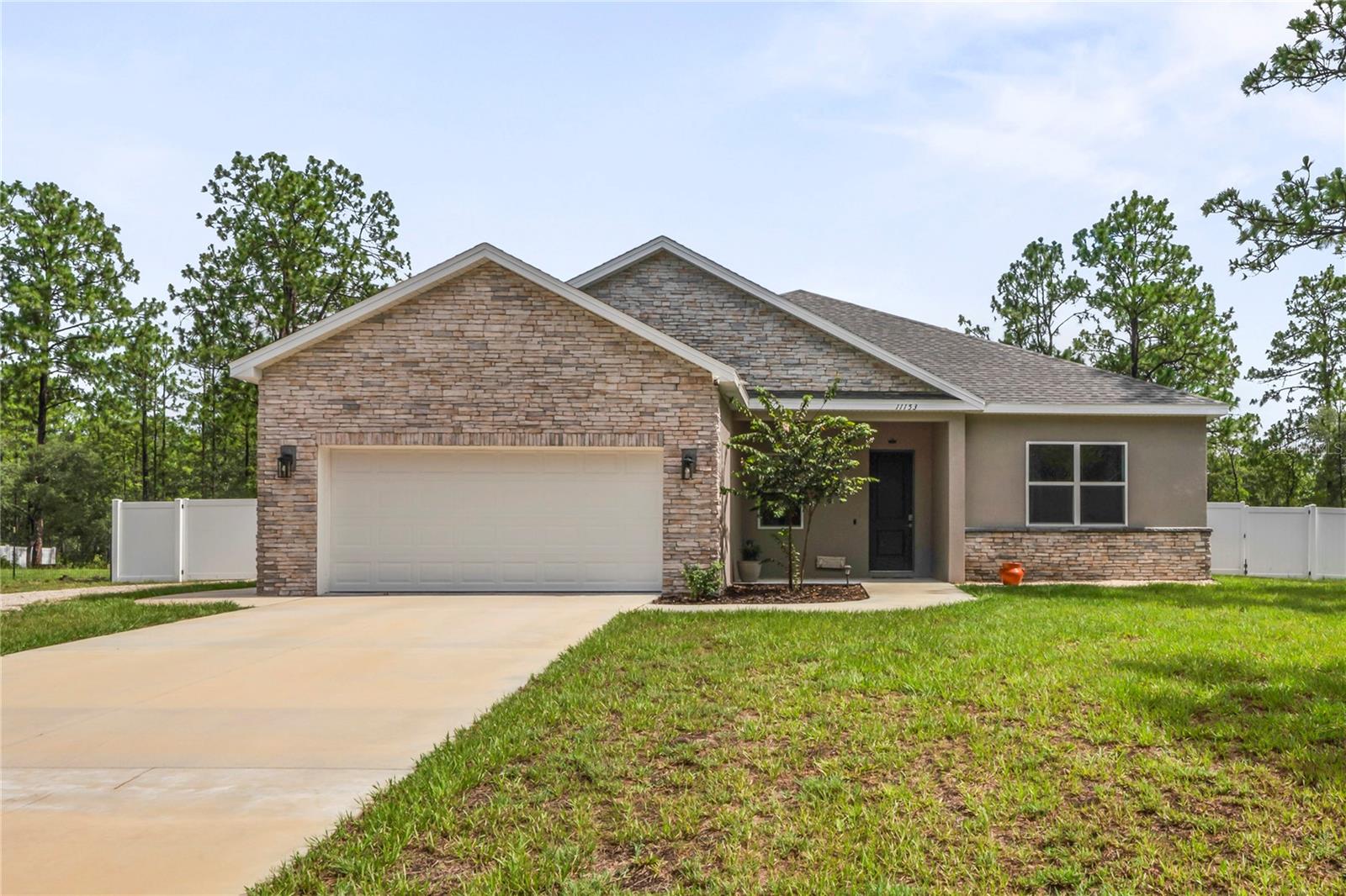 Experience the perfect blend of modern design, quality craftsmanship, and Florida living in this thoughtfully upgraded one-year-new home by Southern Crown Homes. Situated on a high and dry half-acre lot in an established community with ongoing new construction, this property offers more than just curb appeal with its striking stacked stone accents and spacious layout. It offers a lifestyle. Built with insulated concrete form (ICF) construction, this home delivers exceptional energy efficiency, structural strength, and sound insulation, an upgrade that sets it apart from typical new construction. And unlike brand-new builds that often leave you with a long to-do list, this home is truly move-in ready. The backyard is already fenced with a 6-foot privacy fence, and features an extended patio, a hot tub for relaxing evenings, and a shed for extra storage. Step inside to an open concept floor plan with four generously sized bedrooms, offering flexibility and space for family or guests. The oversized owner's suite includes a large walk-in closet and room to create your personal retreat. In the heart of the home, the kitchen features quartz countertops, an upgraded backsplash, and two pantries, making it both stylish and functional. Additional features include an oversized garage with plenty of space for storage or a workshop, a detached carport perfect for an extra vehicle or boat, and a 220V EV charging station for your electric vehicle. Outdoors, enjoy a space that’s ready for relaxation or entertaining. Whether you’re soaking in the hot tub, grilling on the patio, or preparing for a day on the water, this home supports the lifestyle Florida is known for. Located in northwestern Hernando County between Weeki Wachee and Homosassa, you’re within minutes of some of Florida’s best amenities, including an abundance of golf courses, spring-fed rivers, and the Gulf of Mexico. This home provides a peaceful, country setting without sacrificing access to shopping, schools, restaurants, and medical services. Avoid the delays and added expenses of new construction. This beautiful, upgraded home has it all ready for you. Schedule your private showing today and start living the Florida lifestyle you’ve been dreaming of. All furnishings and lawn equipment are negotiable, offering buyers the option to move in with ease or fully outfit a second home.