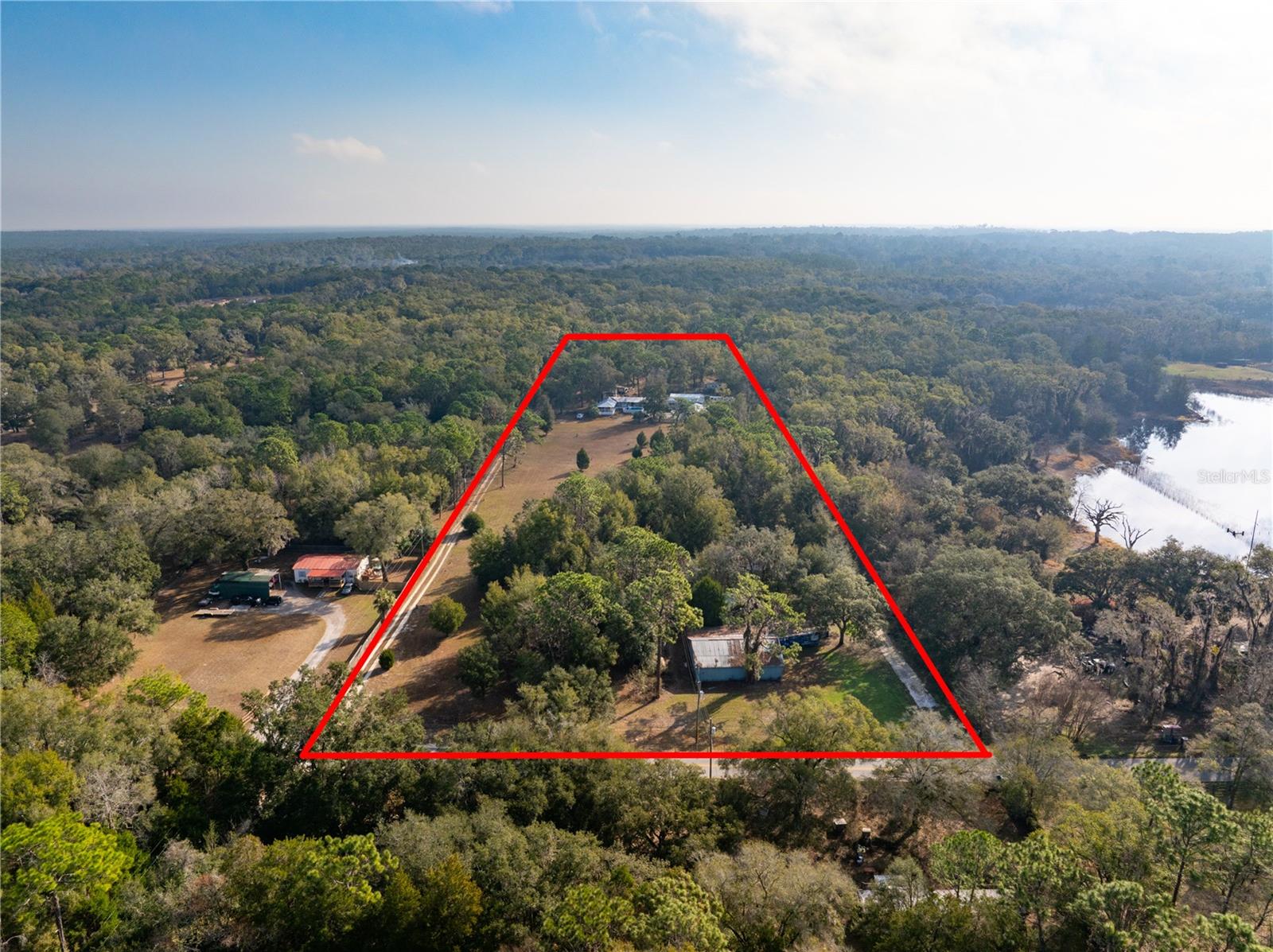 Welcome to your own slice of rural paradise! This stunning 10-acre property offers the perfect blend of natural beauty and practical amenities, making it an ideal setting for a mini farm or equestrian property. Located just a stone's throw away from the Withlacoochee State Forest, outdoor enthusiasts and nature lovers will find themselves immersed in breathtaking surroundings with endless opportunities for exploration and adventure. The property is fenced and features partially wooded land, providing a harmonious balance of open space and shaded tranquility. A newer well/pump is in place, ensuring a reliable water source for agricultural and domestic use. Additionally, the property boasts 4 power poles and 2 septic systems, laying the groundwork for convenient utility connections and potential development. For those with a passion for farming or equestrian pursuits, the agricultural zoning and ample acreage presents endless possibilities. Whether you envision cultivating a thriving garden, raising livestock, or creating a haven for horses, this property provides the canvas for realizing your rural dreams. Adding to the convenience there is a spacious pole barn, ready to accommodate equipment and storage. The possibilities are truly endless on this expansive and versatile property. If you've been yearning for a lifestyle of tranquility, self-sufficiency, and natural splendor, this property presents an extraordinary opportunity to make those dreams a reality. Don't miss your chance to own this captivating piece of countryside bliss. (The Seller does not warrant the condition of any of the mobile homes/strutures on this property. They are not being consider in the value and are assumed to be tear downs)