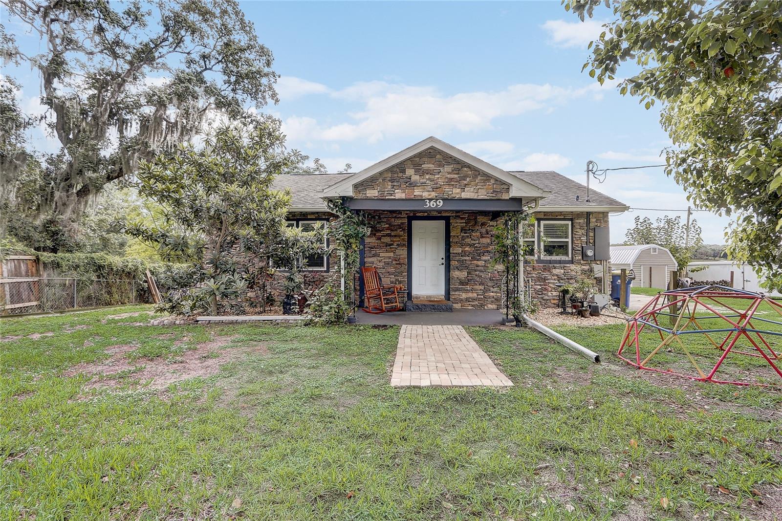 1.67 Acres of Lakefront Living! Welcome home to this lovingly cared for & extensively updated 2bd/1ba cottage on Bluff Lake. Step inside to discover an open and inviting floorplan with LVP flooring seamlessly connecting the main living spaces. Updated kitchen with granite counters & SS appliances. Two generously sized bedrooms with original hardwood floors and shared updated bathroom with tile shower/tub combo. Enjoy beautiful sunrises from your partially enclosed/covered paver patio. Stone exterior, covered front porch, additional concrete patio for extra outdoor living, large shed and established fruit trees (loquat, mulberry and pineapple). The lot is fully fenced with a security gate at the street. Roof 2019 with new gutters and soffits, HVAC with Reme Halo Air Purification System 2018, Water Heater 2017, New Septic System & drain field 2023, Reinforced foundation with fully transferable warranty. This home offers an excellent location with easy access to shopping, dining and more. Don't wait! Schedule your private tour today!