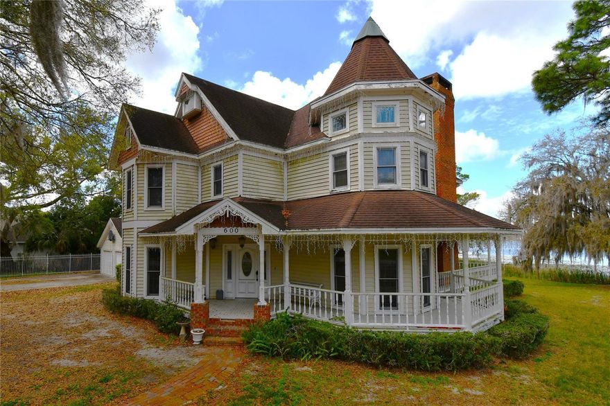 CASH OFFERS ONLY. This classic Victorian on the shores of Lake Gertrude is the definition of a diamond in the rough—full of character, potential, and irreplaceable lakefront views. Set on .95 acres, the property offers stunning sunrise and sunset vistas right from your backyard.
?T?he home does need repairs—including areas of wood rot ?on windows?, doors and porch, some flooring affected by a past water-line issue (now resolved), and other miscellaneous updates?. Both A/C systems were replaced in 2022 and 2023, giving you a solid head start on improvements.
The exterior features are a true bonus: an air-conditioned two-car garage connected by an enclosed walkway, ?and two storage sheds. The oversized pool with a diving board, ?is just waiting for someone to bring it back to life. 
Inside, you’ll find all the charm and architectural detail you’d expect from a Victorian home—just waiting for the right buyer to restore it to its full glory.
Located just minutes from downtown Mount Dora, known for its festivals, boutiques, and small-town charm, this is a rare opportunity to create something extraordinary on one of the city’s most desirable lake?s, Lake Gertrude.