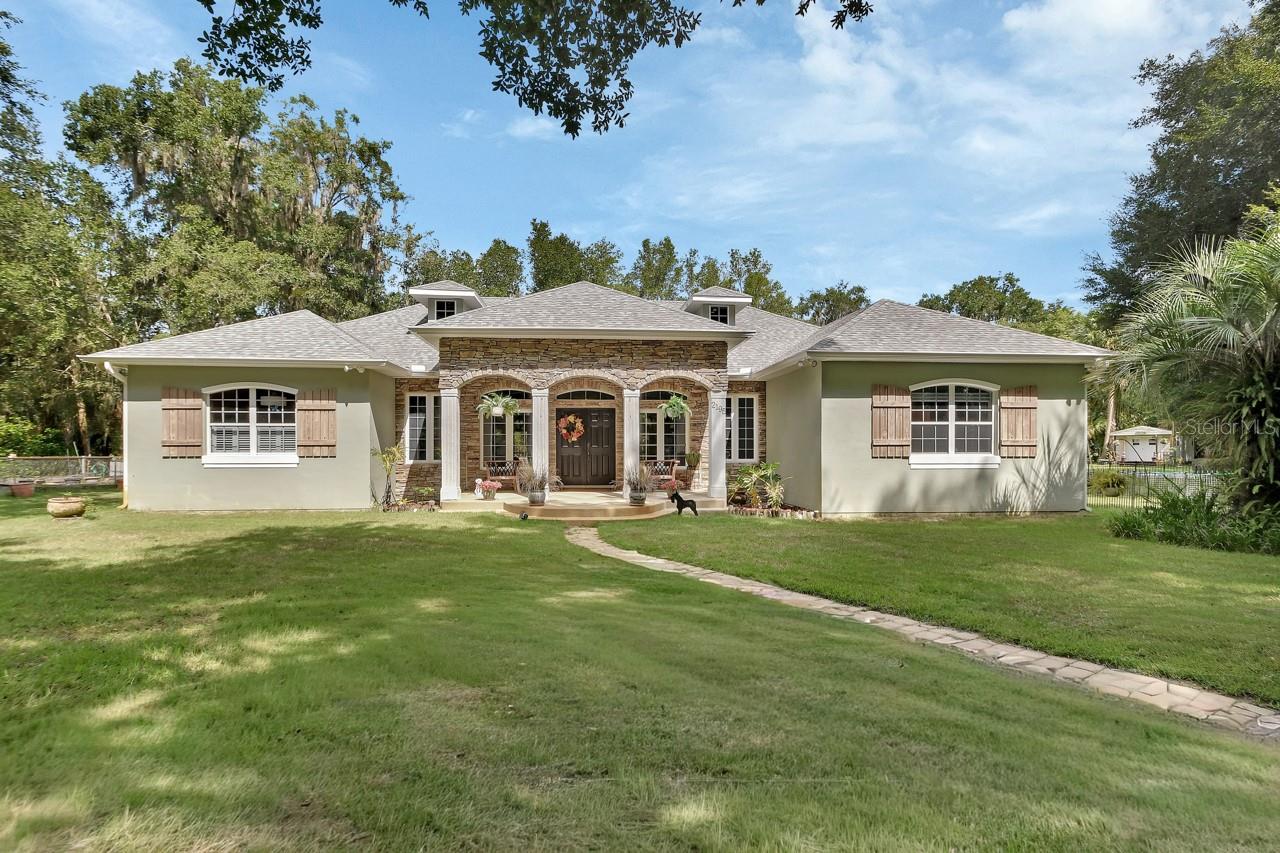 Welcome to your own piece of paradise! This breathtaking property sits on 3.52 beautifully maintained acres with the Lakewood Wildlife Refuge quite literally in your backyard. Imagine sipping your morning coffee from the charming front porch, listening to the peaceful sounds of nature and the faint, relaxing whistle of the train in the distance.
Inside, the kitchen is every cook’s dream and the heart of the home, featuring granite countertops, 36-inch cherry hardwood cabinets, stainless-steel appliances, dual prep areas with sinks, and an island with a butcher block counter and gas cooktop. The open-concept design flows seamlessly from the kitchen into the family and dining rooms, creating the perfect space for entertaining.
3 French doors open from the living room, 1 French door from the dining room, and 1 from the primary suite to the screened lanai. Step outside to enjoy the incredible pool area, complete with three waterfall features, a fire pit on the upper level, and a stunning stone-faced outdoor summer ideal for gatherings and quiet evenings alike.
The spacious primary suite offers a cozy bay window seat, custom walk-in closets, dual sinks, dual showerheads, and a luxurious garden tub. Two additional bedrooms share a Jack-and-Jill bath, while a fourth bedroom doubles as an office with elegant French glass doors.
Beyond the home, three impressive outbuildings provide endless possibilities: a 30’ x 22’ workshop with three doors (perfect for RV, boat, or car storage while still leaving room for projects), a charming “she shed,” and an additional 15 x 20 aluminum building for additional workshop, equipment, recreational vehicles or lawn equipment.
Other highlights include tray ceilings with beam accents, recessed lighting, arched entries, built-in oven and microwave, walk-in pantry, and beautiful tile throughout the kitchen, dinette, and wet areas. Outdoors, a dedicated garden area is ready for those with a green thumb, all tucked away behind a private gated drive just off Grand Avenue in DeLeon Springs.
This property is well maintained and provides a combination of modern amenities, comfort, and country living. You will not want to miss it!
New Roof December 2023, 80 Gallon Hybrid Water Heater 2020, Whole Home Generator 2019, 500 Gallon Propane Tank