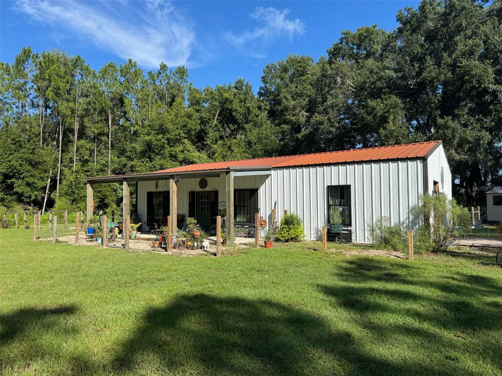 2023 Industrial style custom farm house with copper metal roof on gorgeous 9.92 acres , located on a paved road just before 3 acres of push pastures in the front perfect for horses and gorgeous mature pines with a dream like private drive to showcase this gorgeous custom home. This home is a dream! 2 master bedroom suites with 2.5 bathrooms and a gorgeous open floor plan. This home has an additional 600 sqft concrete pad with footers ready for additional space if needed. Home currently is 1500 H/C sqft of perfection. As you enter the home you will fall involve with the industrial style beams throughout , high end finishes and amazingly unique decorating taste. The kitchen is perfectly tasteful with a Mexican style flare, Mexican tile throughout kitchen with butcher block and granite countertops as well as stainless steel appliances. Laundry room is oversized and spacious and offers an exit in the back yard. Gorgeous LVP flooring throughout the whole home with a double mini split system as well as 2 additional mini splits offering extremely LOW and energy efficient power bills. 10-14 foot high ceilings with closed cell foam insulation makes this home top tier energy efficient. Each master suit is oversized with beautiful light and a view of the quiet countryside. Each bathroom offers custom tile work throughout with gorgeous custom vanities. Windows are dual pane with deep antique brick window sills. Outside it's a mini farm dream. Around the home is fenced perfect for your pets to roam, while the yard can be used for the geese and chickens to free range. Two storage sheds are offered with a 40ft shipping container perfect for storage as well as chicken coop and more. This property offers privacy as the home is quietly tucked behind the pines offering the two pastures in the front open for your horses and donkeys. This property was perfectly build and curated with love and care , no expense was spared. Call today for YOUR tour!