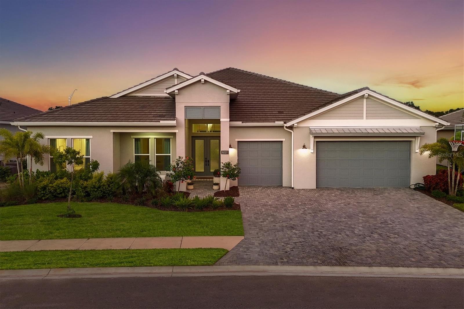 On a private lot with one of the biggest backyards in the prestigious gated community of The Isles at Lakewood Ranch, this enchanting four-bedroom, 3.5-bath, single-story estate has been completely custom designed and is an absolute must-see. As you enter through the custom double glass doors into the impressive grand foyer, you are welcomed by the spectacular European white washed wood floors that flows throughout the home and beckons you into the wide open living spaces with high tray ceilings, custom window treatments, beautiful wood beams, timeless architectural details, stunning designer lighting and thoughtful details that continues throughout. Going in further, you’ll awed by the exotic marbled built-in that is the showpiece of the spacious dining area and complemented but the stunning chandelier and wood beam ceiling. The dining room effortlessly connects to a generously sized grand living area, making it an entertainer's dream. The great room is anchored by a striking custom marble fireplace, surrounded by beautifully crafted built-in cabinetry and accented by the warm, rich beams in the tray ceiling. At the heart of the home, the kitchen is designed to exceed all expectations with an oversized quartz island, upgraded JennAir and Maytag appliances, gas cooktop, impressive storage solutions in the beautifully crafted cabinets with brushed gold hardware, quartz counters, custom backsplash and a generous walk-in pantry. This beautifully designed space flows effortlessly through expansive disappearing corner pocket sliders, extending your living area onto the oversized lanai and into the spacious backyard. With ample room to add a custom pool, though the stunning community pools are just a short distance away, there is no immediate need to build your own. The primary suite is an absolute oasis with views of the beautiful backyard, generous dual closets and a spa-inspired bath adorned with large-format marble-inspired tile, a soaking tub, walk-in shower and dual vanities with built-in vanity. A private guest wing offers three additional bedrooms—one with a dedicated en-suite bath and two that share a stunning bath with impressive details—ensuring comfort and privacy for family and guests alike. This home also offers a spacious laundry room with upgraded appliances as well as built in cabinetry for additional storage and a convenient drop zone area off the three-car garage for hanging backpacks, jackets, umbrellas and other needed travel accessories. The Isles is one of the prominent villages in Lakewood Ranch. Residents enjoy a coveted gated community lifestyle, complete with an elegant clubhouse offering lounge areas, amenity center, cabanas, dog park, event lawns, fishing pond, fitness center, basketball, pickleball, playground, resort and lap pools, social room, spa, tennis courts as well as scenic walking trails, a meditation lawn, dog park and tranquil lakes that define this premier Lakewood Ranch neighborhood.