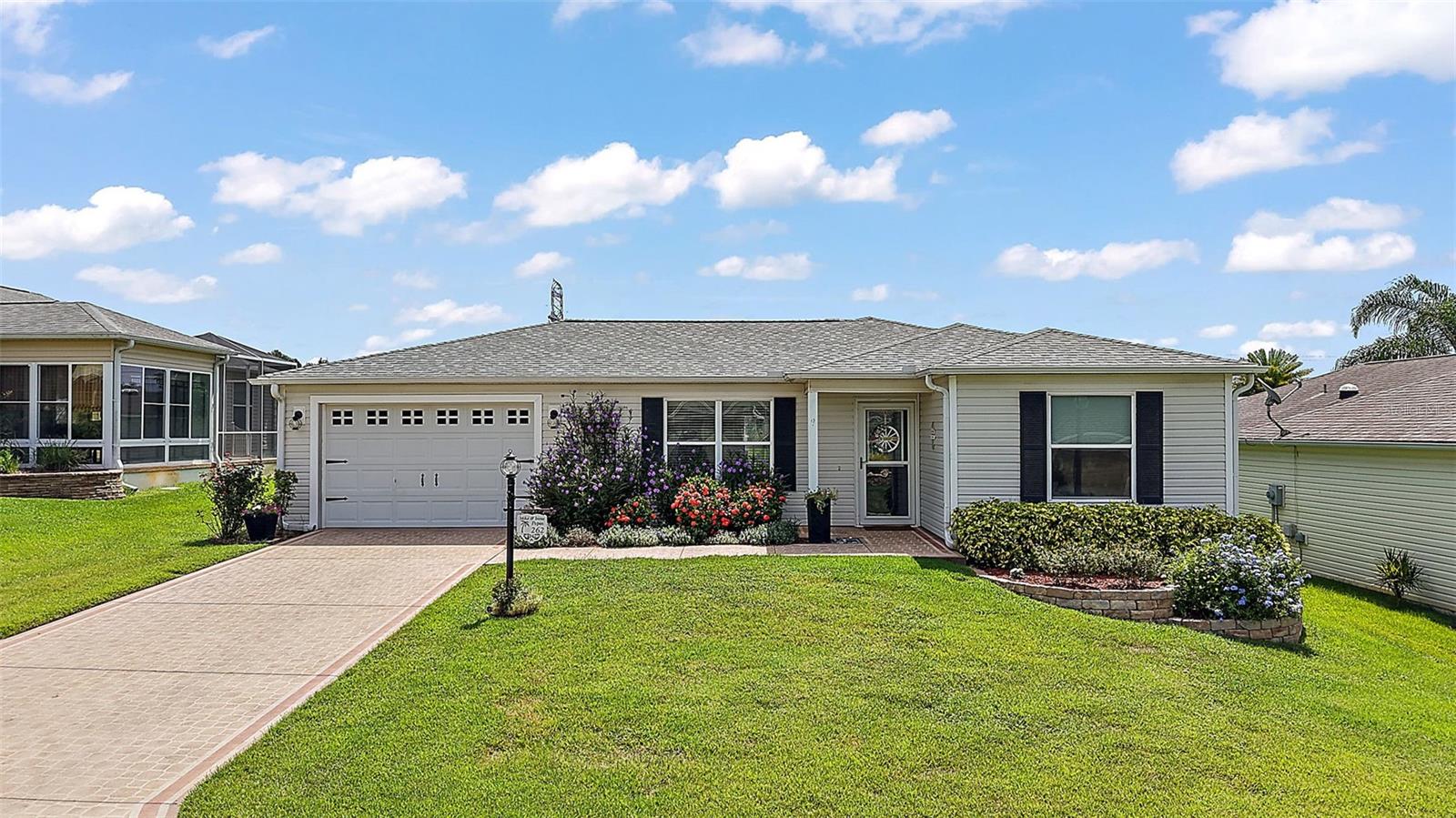 This charming Austin model in the village of AMELIA is ready for you to enjoy! It features 2 bedrooms, 2 bathrooms, and a 2.5-car garage. As you approach, the painted driveway and mature landscaping create an inviting atmosphere. Upon entering through the glass storm door, you are welcomed into an open floor plan that boasts vaulted ceilings and laminate vinyl flooring. The living room seamlessly connects to the eat-at bar and kitchen, which is equipped with granite countertops and pullout cabinetry, along with appliances that are less than 5 years old. The guest bedroom is enhanced by a larger window and a fan/light combination, with the guest bathroom conveniently situated nearby. The owner's suite showcases updated lighting, a walk-in shower, and an ensuite bathroom featuring granite countertops and a step-in glass shower. Savor your coffee on the screened lanai while listening to the soothing fountain and taking in the view of the pergola and mature landscaping. In addition, several improvements have been made: the AC was updated in 2022, Roof 2025, hot water heater in 2020, and interior was painted in 2021. This property is centrally located, with shopping, restaurants, and doctors nearby, and Lake Sumter Landing is just a short 15-minute golf cart ride away, along with the Colony recreational center located around the corner. Don't miss this home, call today!