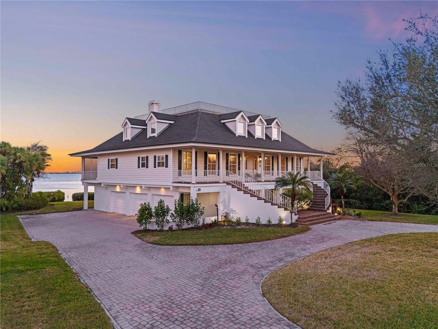This is Southern living at full gallop, equal parts elegance, tradition, and undeniable presence from the very first moment. Offered for the very first time by its original owner, this truly one-of-a-kind Coastal Southern Colonial estate is among the rare freestanding residences on prestigious Tidy Island, gracefully positioned along the shimmering waters of Sarasota Bay behind the community’s private gates. Reminiscent of the timeless coastal estates featured in classic design magazines, this residence invites a slower, more refined way of life where mornings begin with coffee overlooking the water, dolphins surface just offshore, wading birds glide past the shoreline, and evenings conclude with the sparkling skyline lights of downtown Sarasota dancing across the bay.

Inside, a grand foyer welcomes you to gracious living spaces including a classic parlor with fireplace, formal dining room, expansive kitchen with breakfast nook, and beautifully proportioned rooms designed for both comfortable living and memorable entertaining. The primary suite is thoughtfully located on the main living level and features dual walk-in closets along with a spacious en suite bath complete with soaking tub and steam shower. Upstairs, three generously sized guest bedrooms, two full baths, and a versatile loft area provide the perfect retreat for family and visiting guests. The lower level offers additional functional space along with a walkout lanai that opens directly to the backyard and seawall, creating seamless access to the waterfront setting.

Built with enduring craftsmanship and attention to detail, the property also includes a private elevator, oversized three-car garage, multiple storage rooms, and a circular paver driveway that complements the estate’s stately presence.

Residents of Tidy Island enjoy a unique coastal lifestyle surrounded by natural preserves, walking trails, private roads, and community amenities including tennis courts, pools, clubhouse facilities, and kayaking opportunities, all within minutes of IMG Academy, Bradenton Christian School, Saint Stephen’s Episcopal School, Sarasota-Bradenton International Airport, the Gulf beaches of Anna Maria Island, and the vibrant new Seaflower shopping and dining district under construction just beyond the gates.

Homes of this character rarely become available, offering the opportunity to own one of Manatee County’s most distinctive waterfront estates while enjoying the added convenience and peace of mind of maintenance-free living.