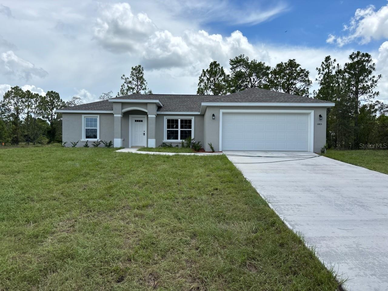 NEW CONSTRUCTION. MOVE-IN READY! This beautifully designed Islamorada model features 3 bedrooms, 2 bathrooms, and 1,405 square feet of comfortable living space, all situated on a generous 1/3-acre corner lot on a quiet street in Citrus Springs, with very few neighbors nearby. The open floor plan features a vaulted ceiling in the living room and luxury vinyl plank flooring throughout for a clean, modern look. The kitchen shines with wrap-around custom white shaker cabinets with soft-close drawers, granite countertops, a large pantry, stainless steel appliances, and a classic subway tile backsplash. Both bathrooms include upgraded marble-look tile, with a tub/shower combo in the main bath and a glass-enclosed shower in the master. The spacious laundry room adds convenience with upper cabinets for extra storage. Enjoy relaxing on the covered patio or take advantage of the attached 2-car garage, complete with an opener and remotes. Built with concrete block construction, a durable 30-year architectural shingle roof, and energy-efficient double-pane windows, this home also includes a 10-year structural warranty. Located in Flood Zone X, this property is elevated and dry, and therefore does not require flood insurance. Plus, with no HOA fees, you’ll enjoy added freedom and peace of mind.