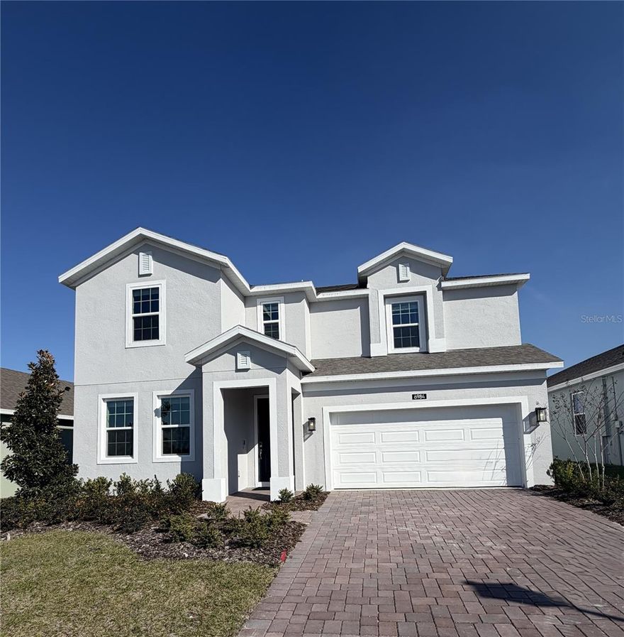 Discover the only Move-In Ready Newcastle plan available in Eagletail Landings with no rear neighbors! This exceptional home offers privacy and space in a beautifully designed open-concept layout. Featuring 9'4" first-floor ceilings, this home includes a total of 5 bedrooms and 3.5 baths, with a convenient first-floor guest bedroom and adjacent full bath. The spacious family room and café area flow seamlessly to a covered rear lanai, ideal for entertaining and outdoor living. The upgraded kitchen showcases 42" cabinets, quartz countertops, and stainless steel appliances, while tile flooring throughout the first-floor living areas and window blinds throughout add both style and convenience. Upstairs, a versatile family room/loft provides flexible space for a media room, exercise suite, or retreat. The Primary bedroom impresses with an en-suite bath featuring a walk-in closet, dual sinks with adult-height vanity, beautiful countertops, and a luxurious walk-in shower with wall tile surround, making this home a perfect blend of comfort, function, and modern design. Exterior features include attractive landscaping and brick paver driveway and lead walk for great curb appeal. Future Community amenities will include Resort-style Pool and shaded Playground. Eagletail Landings is located just south of Lake Harris and near some of the best outdoor recreation in the state as well as Lake County's breathtaking chain of lakes and scenic trails, and a thriving downtown area is just a short drive away, along with 2 nearby championship golf courses designed for a challenging and enjoyable day on the greens.