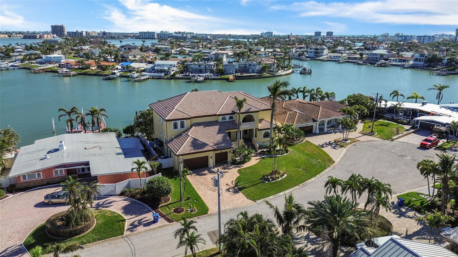 This elevated 5,798 sq. ft. waterfront estate in Yacht Club Estates combines timeless elegance, modern convenience, and unmatched structural integrity. With 117 linear feet of seawall, it’s a boater’s dream—complete with a 15,000 lb. boat lift and floating dock. Built on engineered landfill to raise the elevation, the home remained safe during Hurricane Helene, with only 2 inches of water entering the garage while nearby homes suffered over 2 feet. Solid block and poured concrete construction, a commercial-grade Epicore second-floor system, hurricane-impact windows and doors (rated to 150 mph), a 12-inch raised seawall, and whole-house generator hookups deliver lasting peace of mind. The 5-bedroom, 5-bath layout includes a downstairs bedroom perfect for a private office, a theater-ready media room with projector and recliners, an upstairs game room with wet bar, wine rack, and gym platform, plus a loft with two built-in desks, bookshelves, and file storage. The open-concept kitchen is a chef’s dream, featuring Wolf appliances including a double oven with griddle and grill, steamer, warming drawer, Sub-Zero fridge with filtered water, dual Fisher & Paykel dishwasher drawers, full and prep sinks with disposals, a walk-in pantry, and built-in desk. Nearly every room captures stunning water views. Custom California Closet systems enhance every closet and pantry. Step outside to enjoy two oversized balconies with sunrise and sunset views, and a resort-style PebbleTec saltwater pool and spa (with new 2024 heater and 2025 pump). The outdoor kitchen is fully equipped with a 2025 grill with rotisserie, sink, and beverage fridge—perfect for entertaining. The spacious downstairs primary suite includes a gas fireplace, private terrace access, spa-like bath with steam shower, jetted tub, dual sinks, makeup vanity, and an oversized walk-in closet. Additional highlights: 3-car garage with epoxy floors, EV charging station, natural gas throughout with hookup for a future fire pit, wood-planked outdoor ceilings, and a utility room with extra storage. This rare waterfront gem is priced to sell—offering luxury, safety, and smart design in one of St. Petersburg’s most coveted neighborhoods.